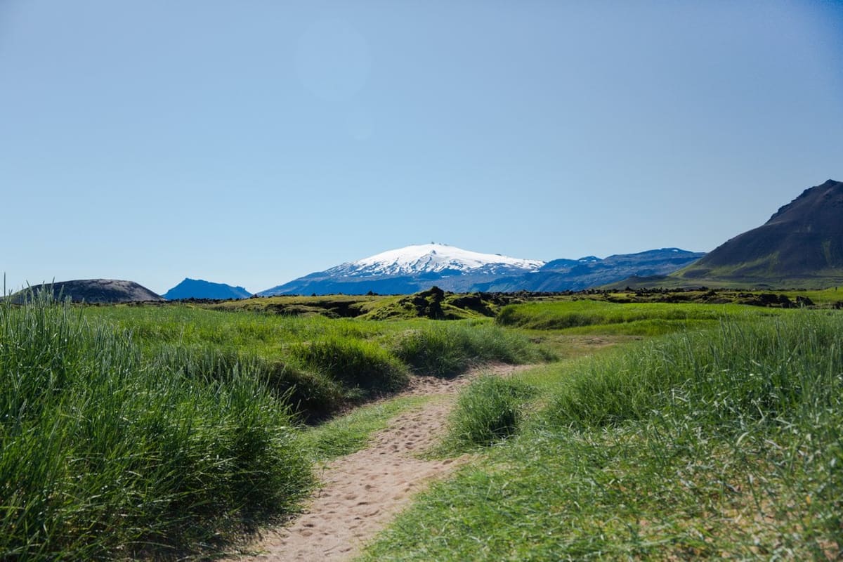 Path through grass toward Snæfellsjökull and Snæfellsnes mountains.