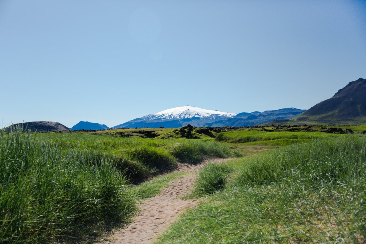 Path through grass toward Snæfellsjökull and Snæfellsnes mountains.