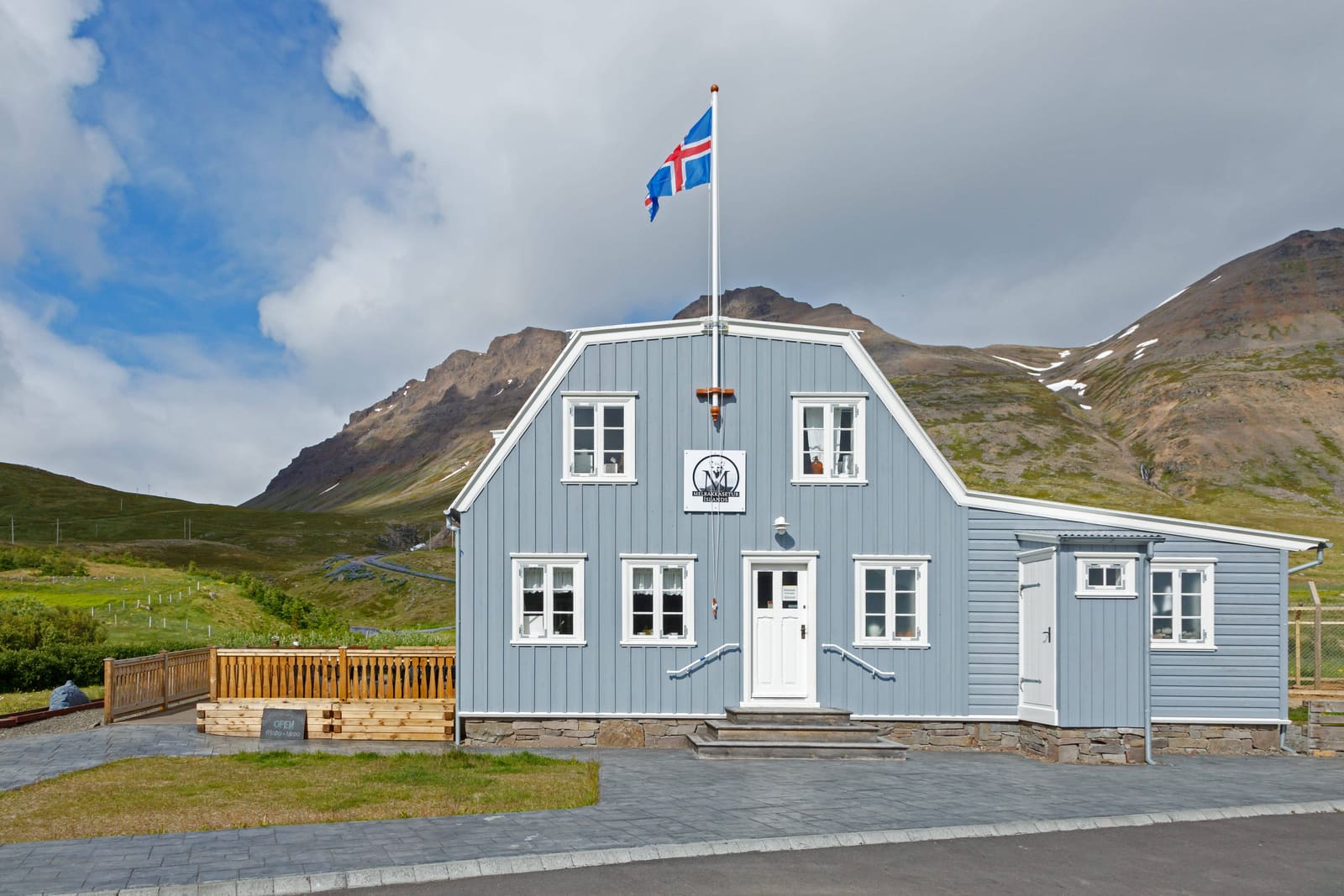 Front of the Arctic Fox Centre building in Súðavík with mountains behind it.