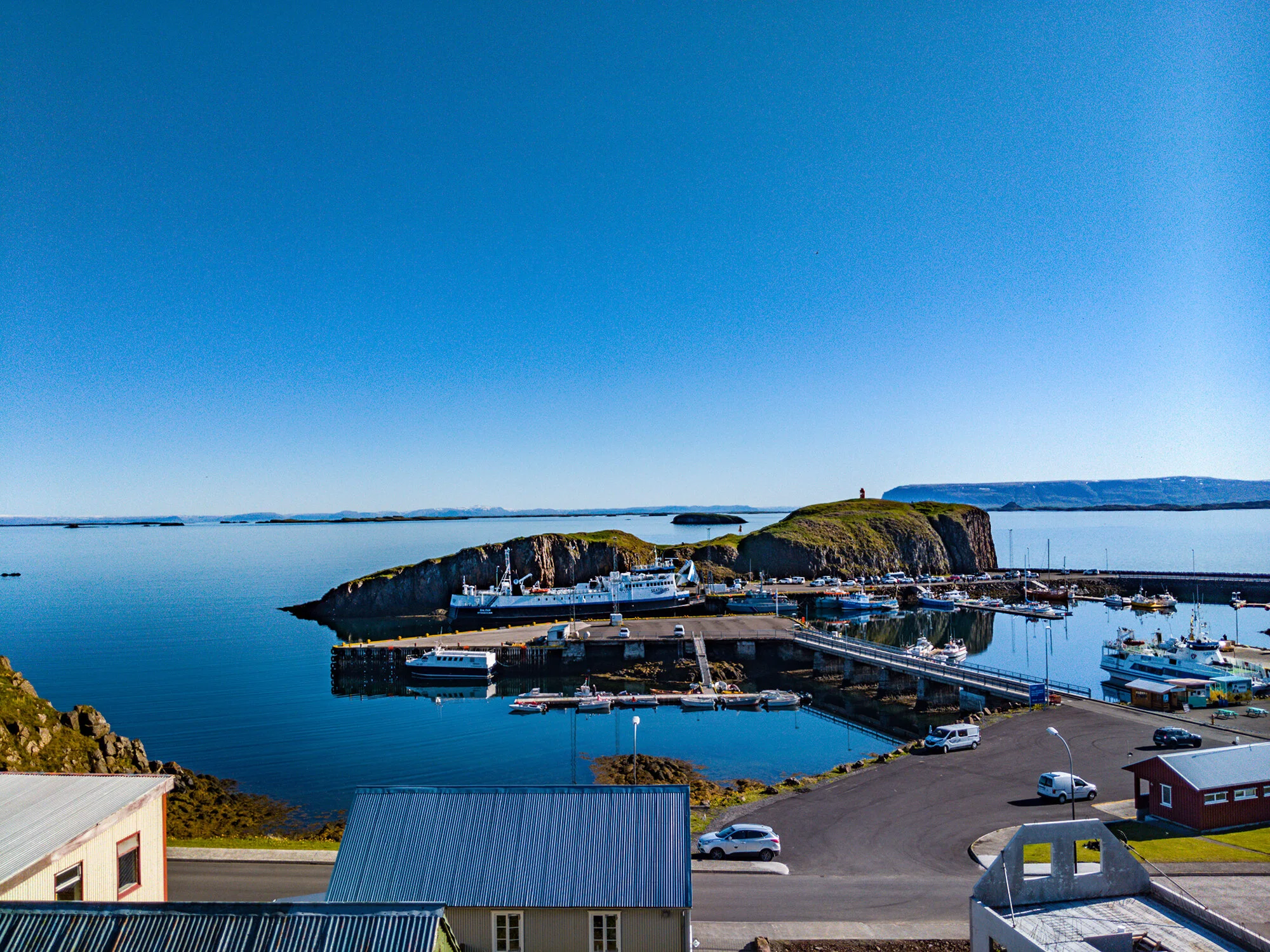 Close view of the red Súgandisey lighthouse above the basalt island by Stykkishólmur harbor.