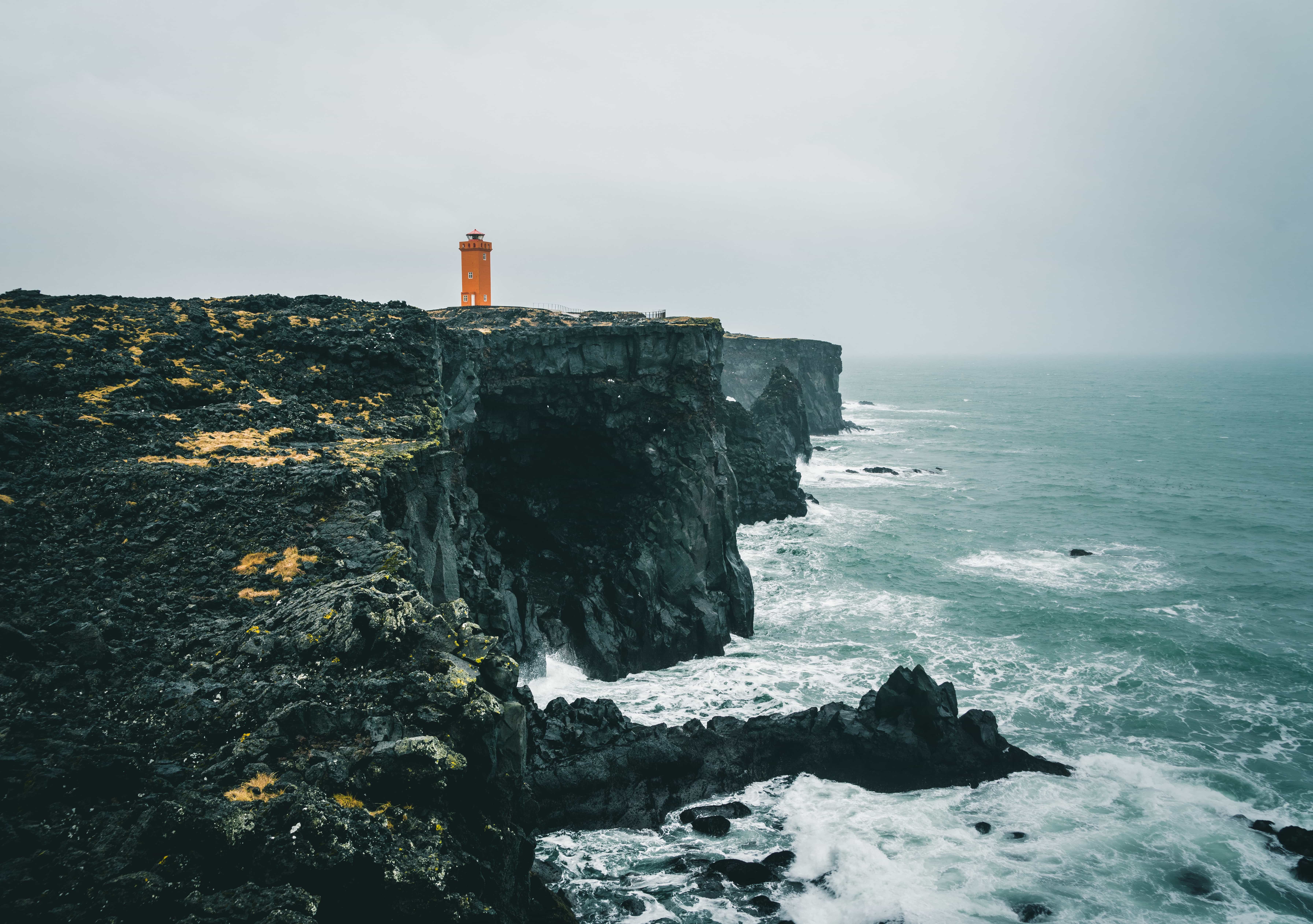 Svörtuloft lighthouse above the steep basalt cliff edge and open Atlantic water.
