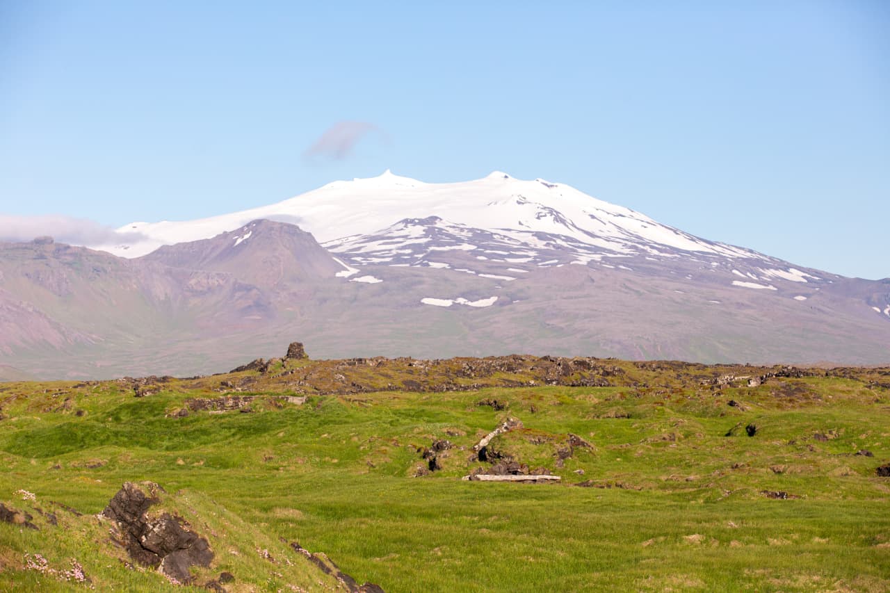 Snæfellsjökull rising beyond the grassy Öndverðarnes headland near Svörtuloft.