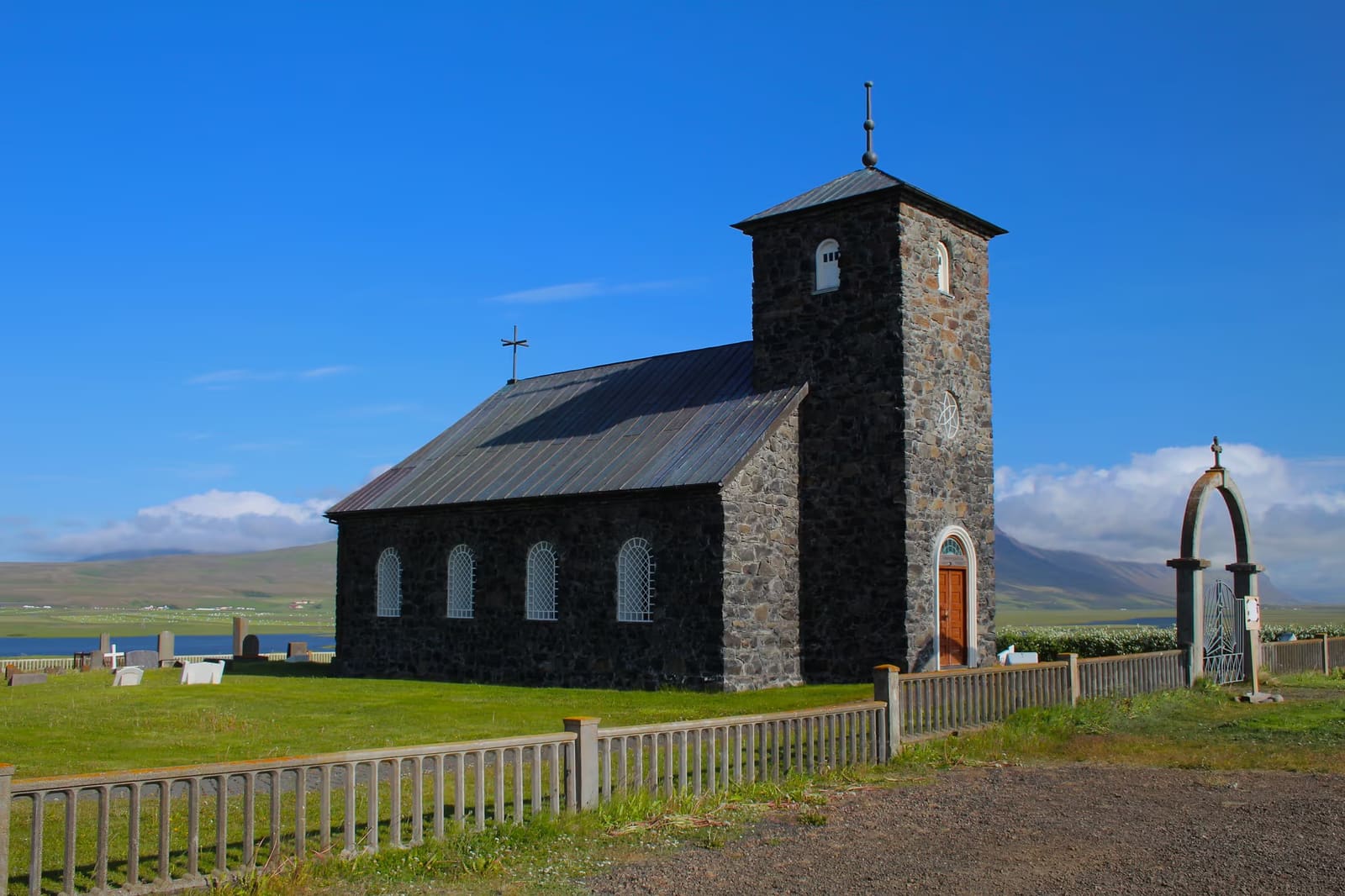 Þingeyrarkirkja stone church beside its churchyard in North Iceland.