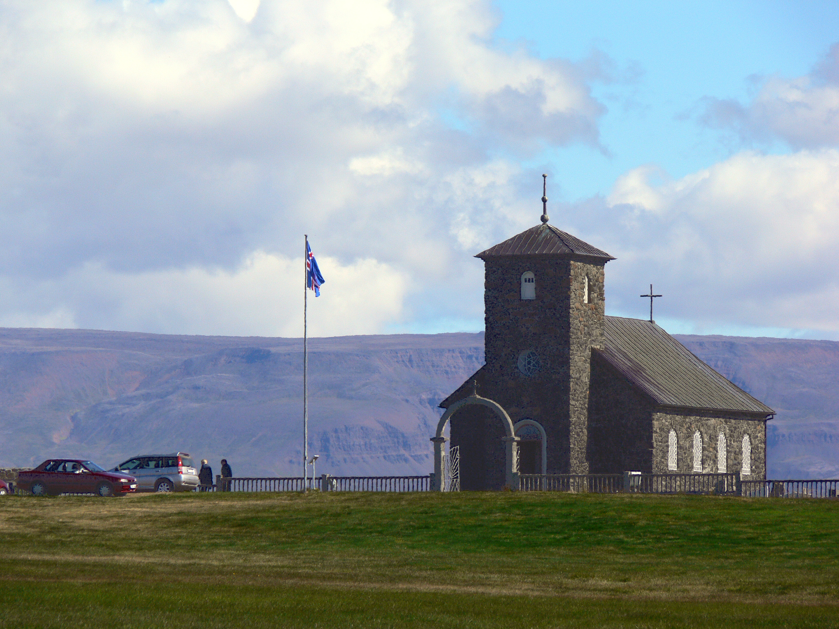 Þingeyrarkirkja Church standing in open North Iceland countryside below broad clouds.