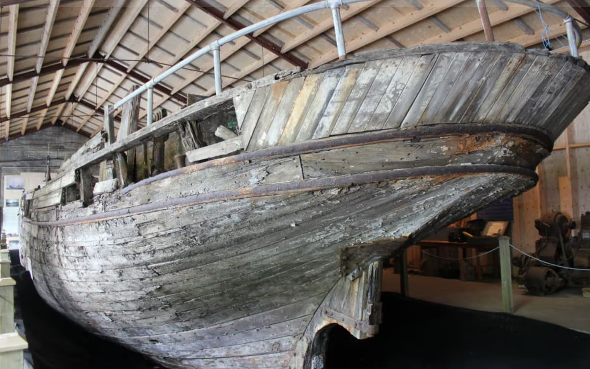 Side view of the preserved Skaftfellingur wooden boat inside the museum.