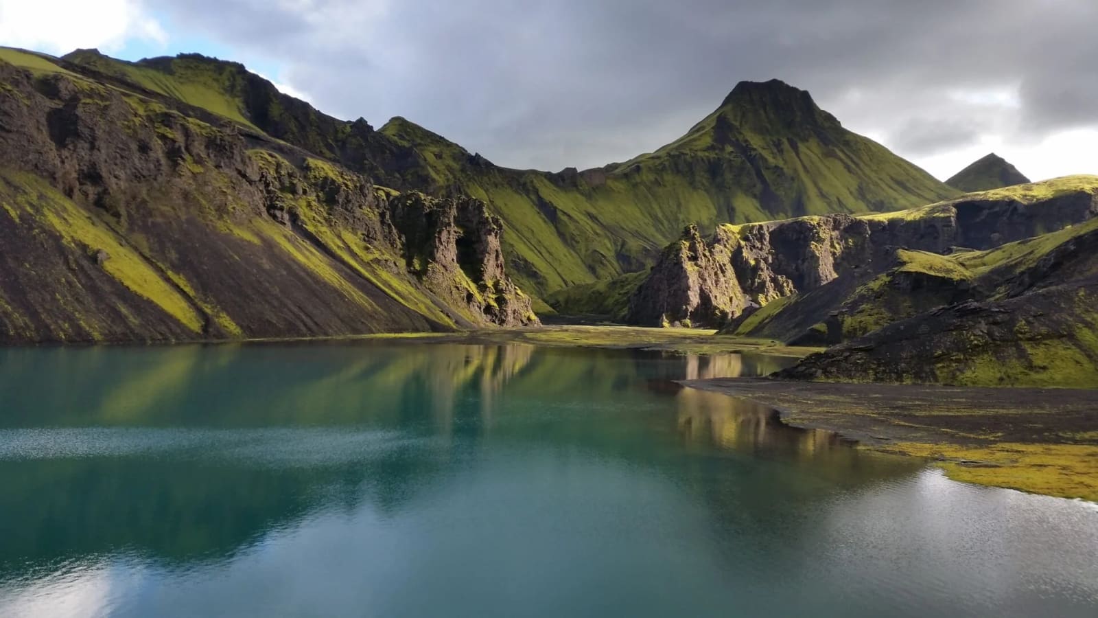 Uxatindar mountains rising beside a small highland lake.