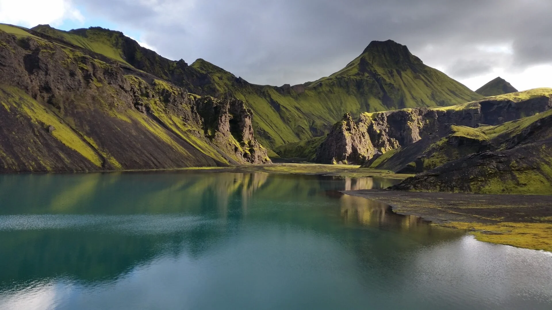Uxatindar mountains rising beside a small highland lake.