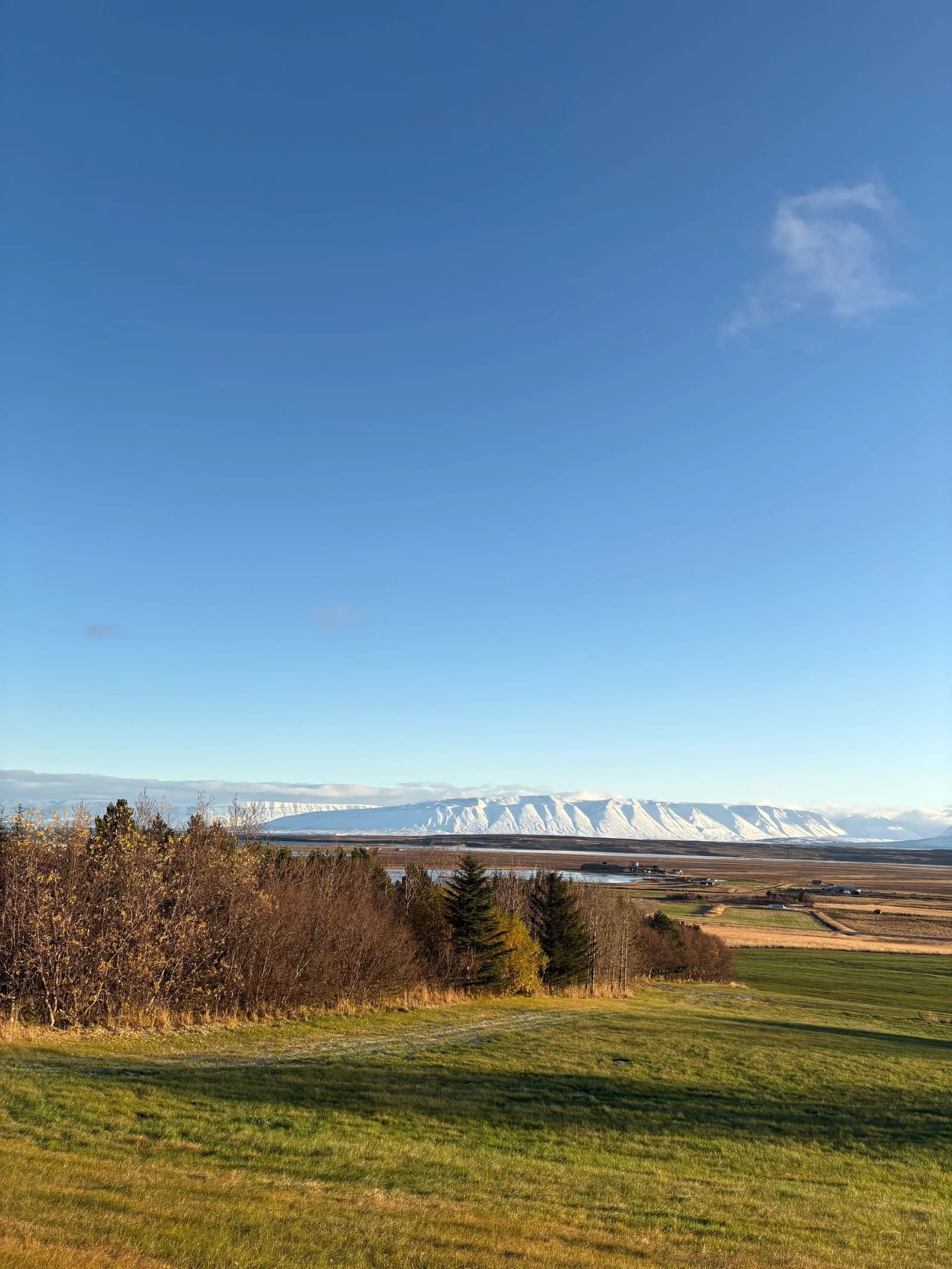 View from the Varmahlíð area across fields and snowy Skagafjörður mountains.