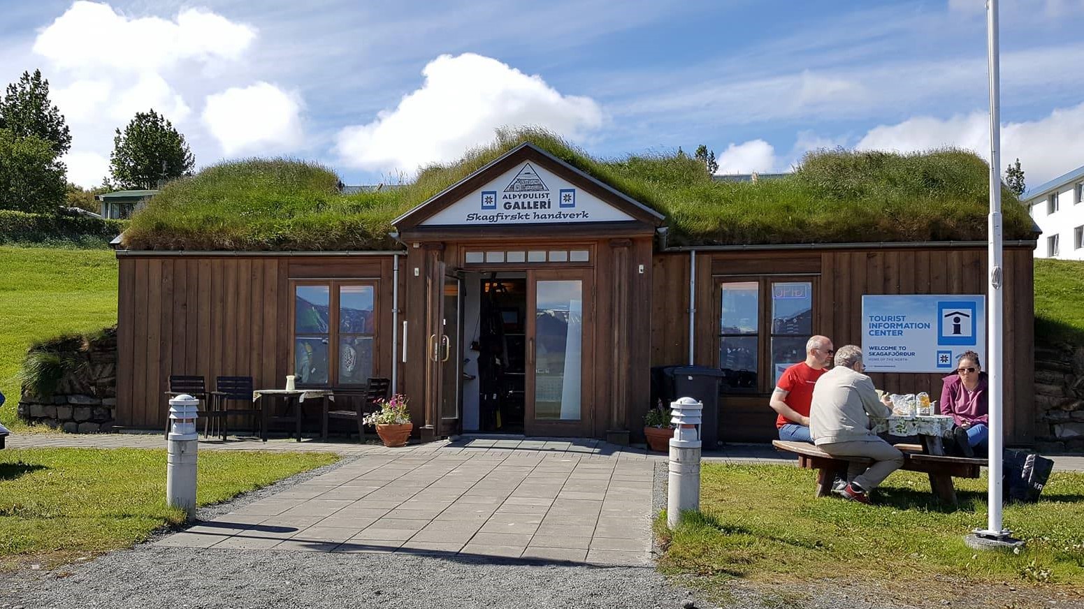 Turf-roofed Varmahlíð regional information center beside the village road.