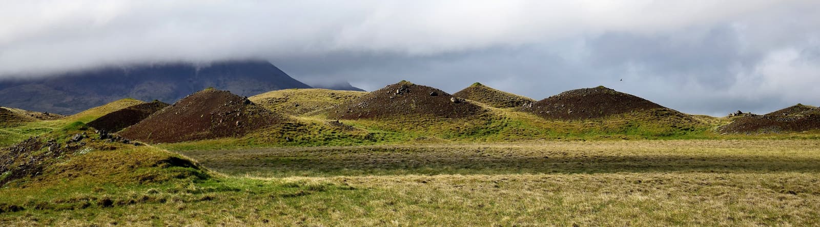 Wide band of rounded Vatnsdalshólar mounds beneath a cloudy North Iceland sky.