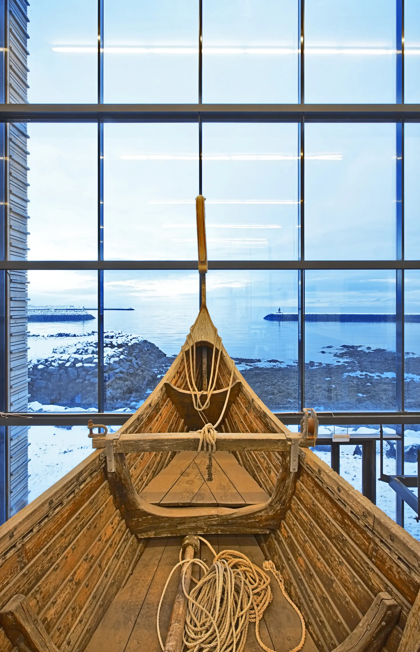 The Íslendingur ship replica inside Viking World with the bay visible through the glass wall.