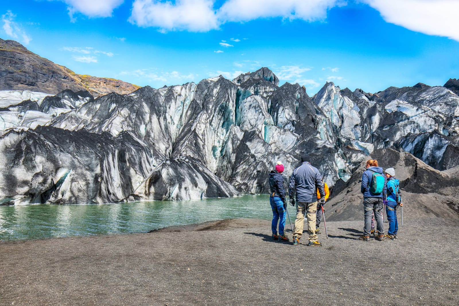 Travelers facing a South Coast glacier on an Iceland route
