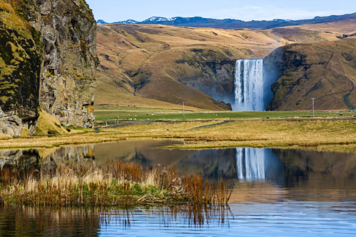 Skógafoss waterfall dropping from a green cliff on Iceland's South Coast