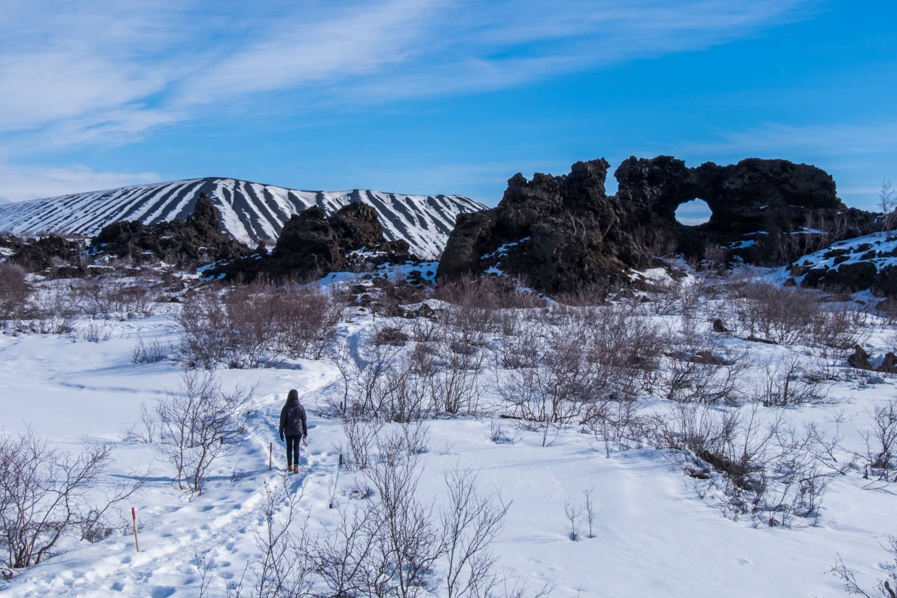 A winter path leads toward lava formations in the Mývatn area of North Iceland.