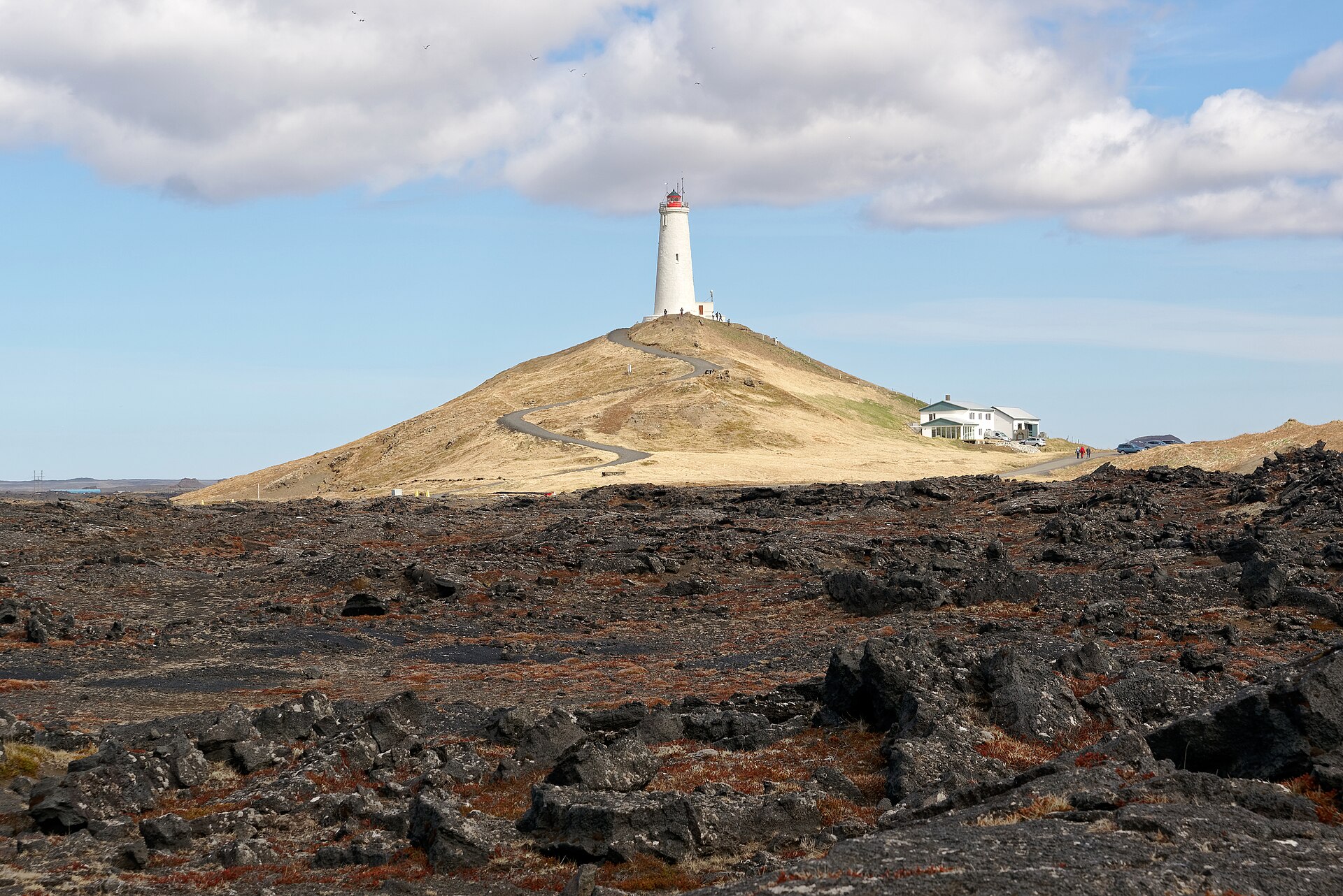 Reykjanesviti lighthouse stands above black volcanic ground on the southwest Reykjanes route.