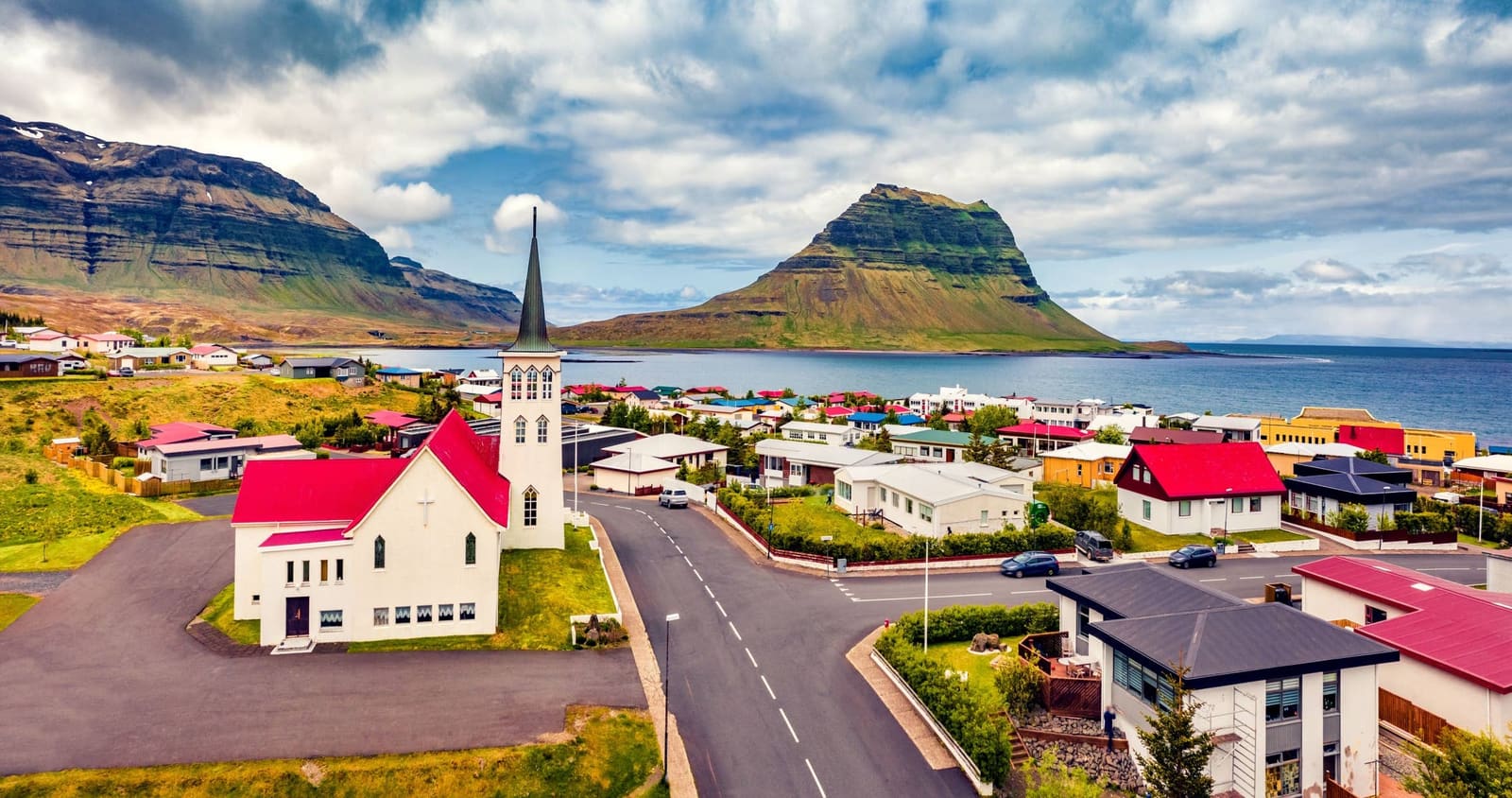 Grundarfjörður sits below Kirkjufell with a road running through the town.