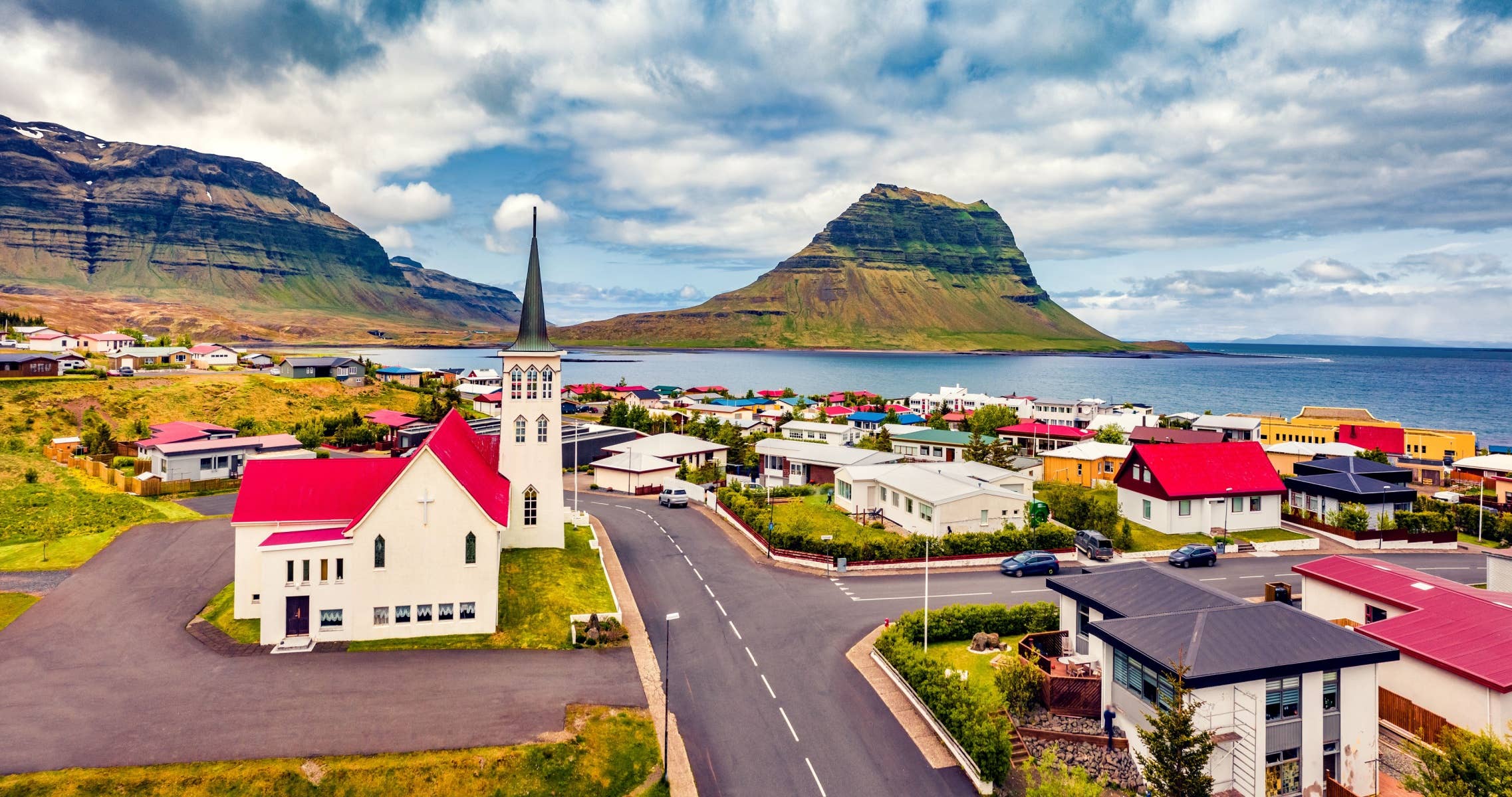 Grundarfjörður sits below Kirkjufell with a road running through the town.