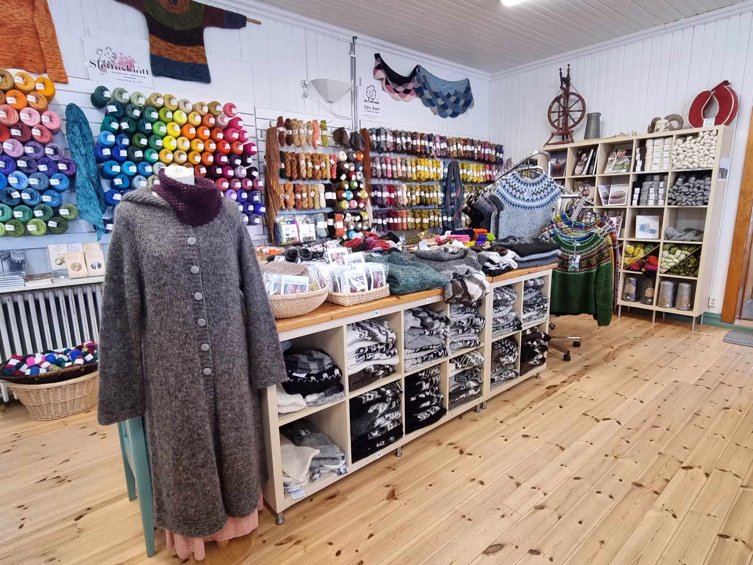 Shelves of colorful yarn and Icelandic lopapeysa sweaters inside Þingborg wool shop