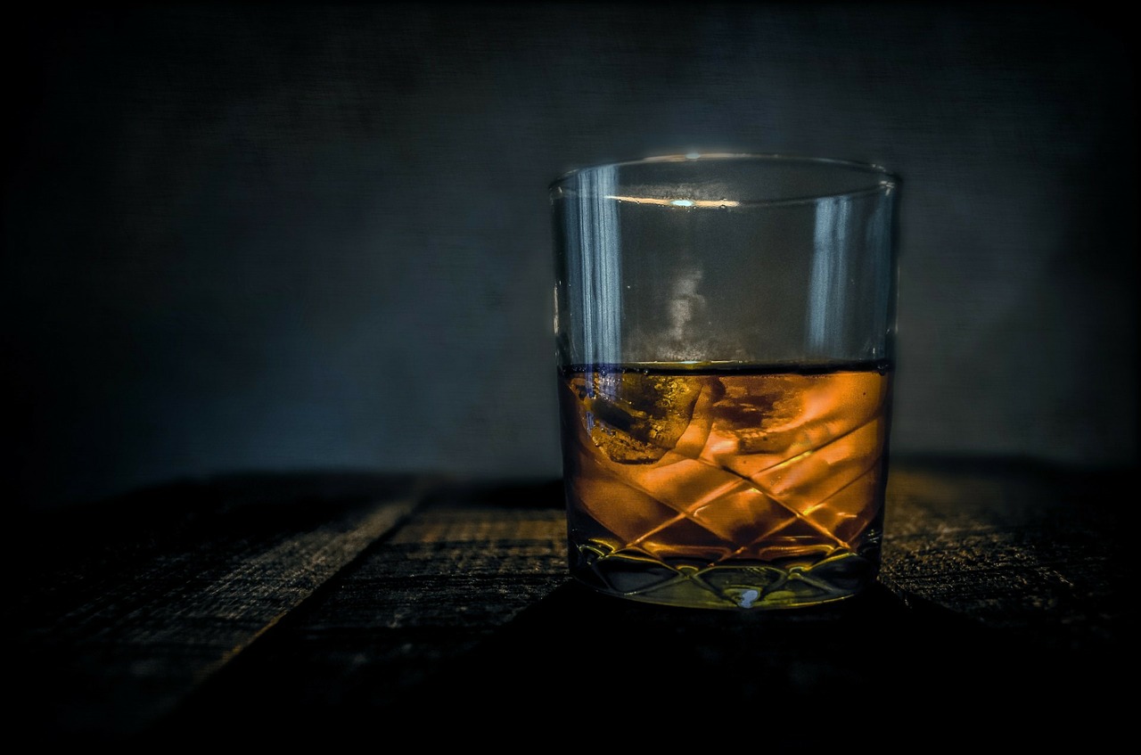 Plain whisky glass in warm light representing a structured spirit tasting
