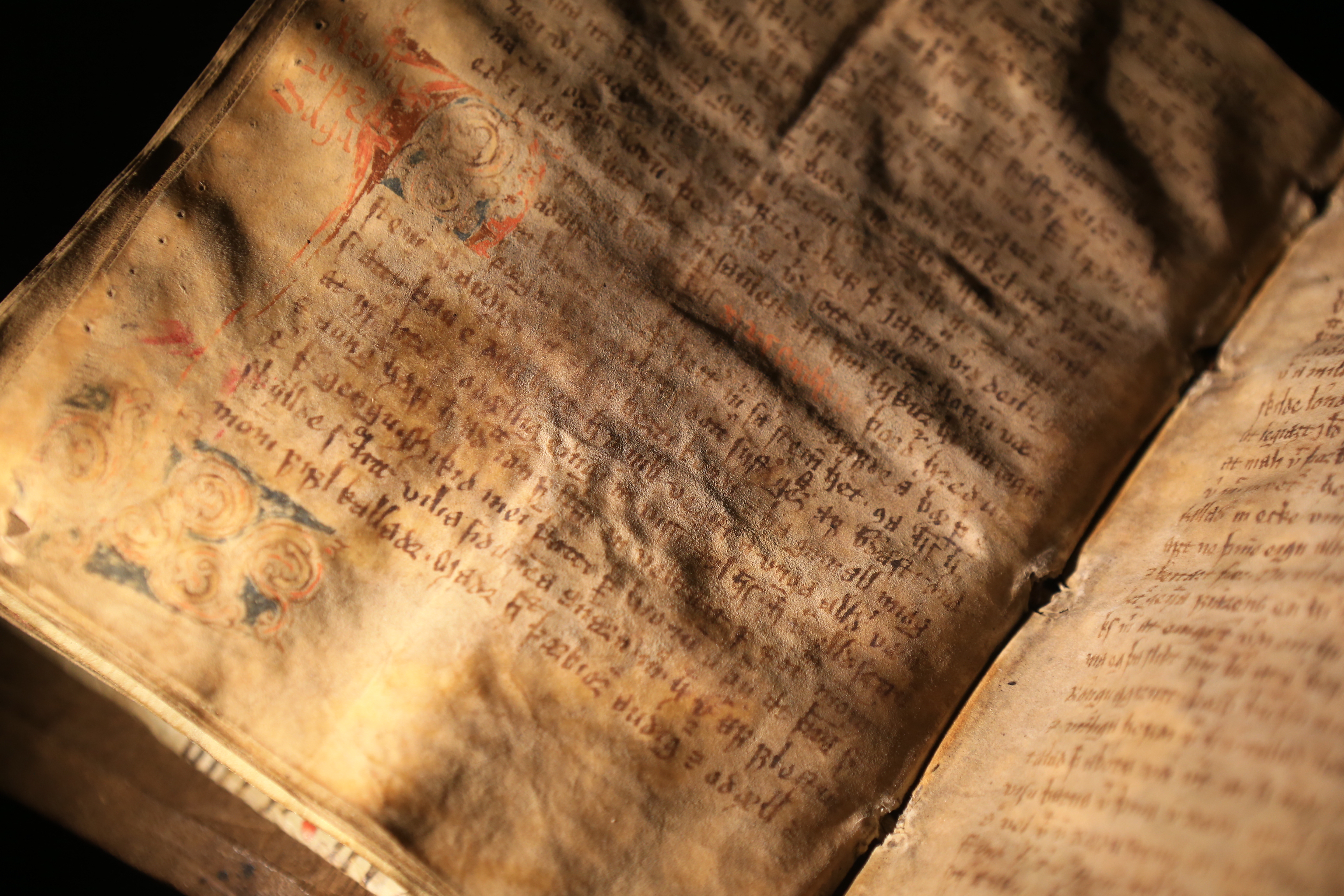 Illuminated Icelandic manuscript open to handwritten text and painted decoration