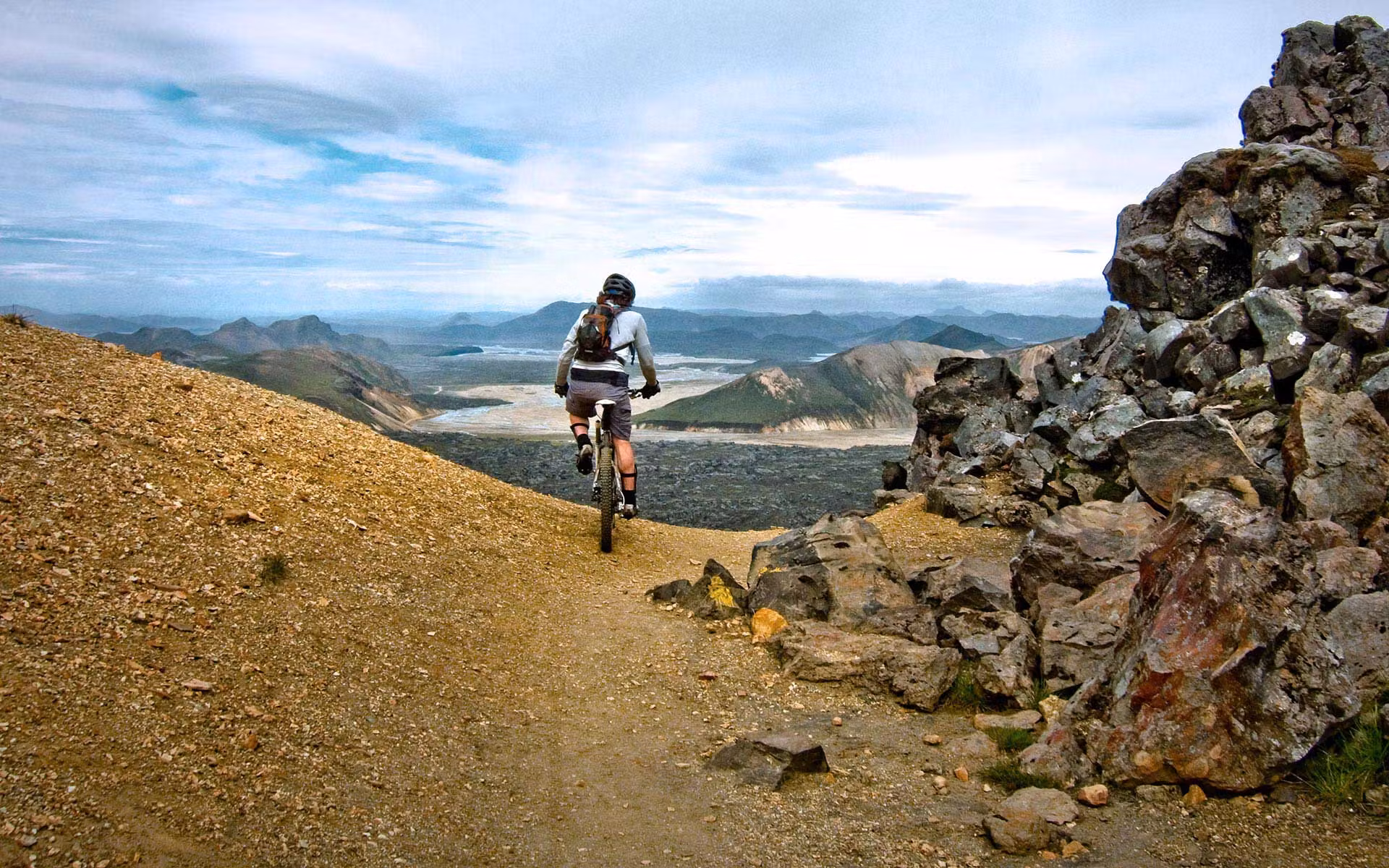 Cyclist riding a narrow rocky trail through Iceland's remote Highlands