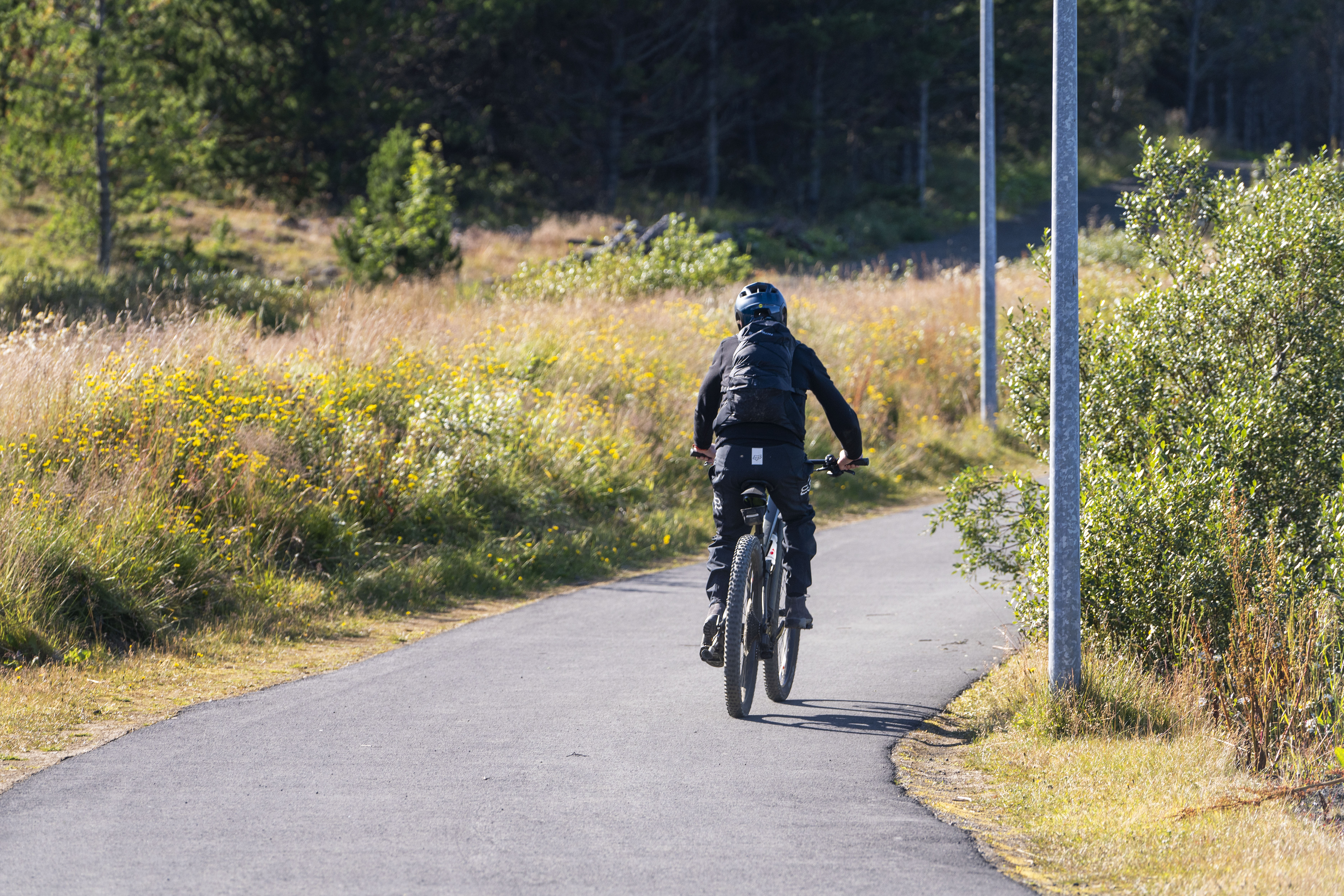 Cyclist following a paved path through green space at Rauðavatn in Reykjavík