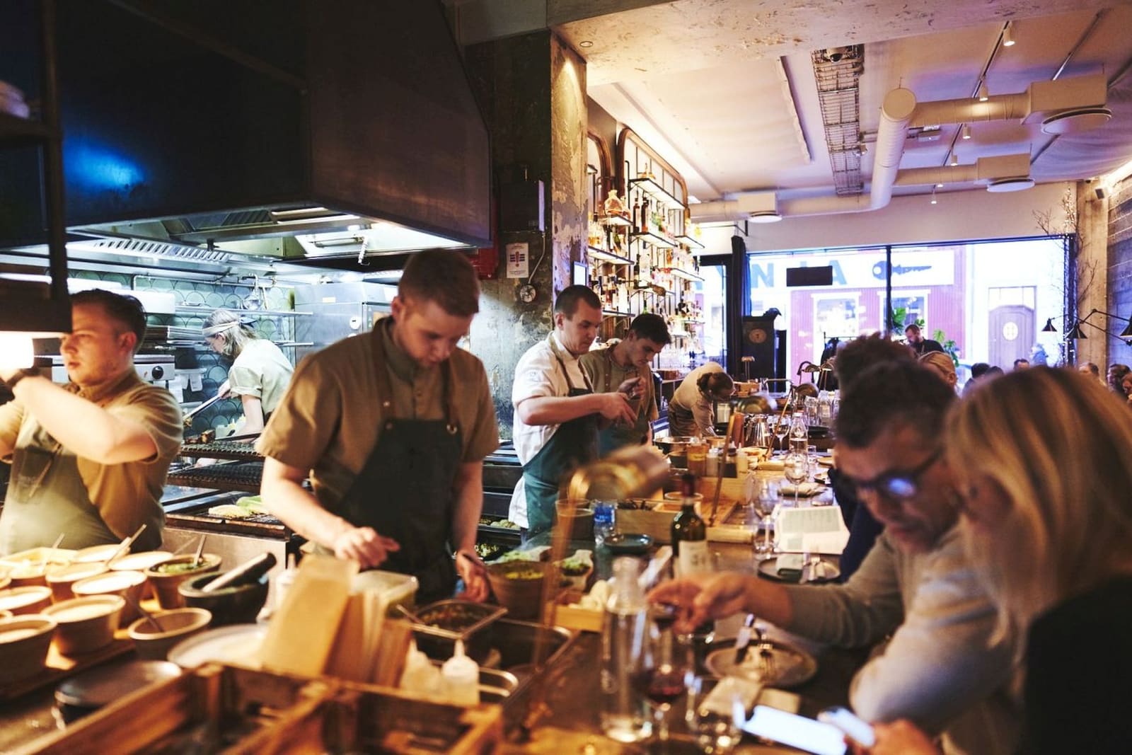 Chefs plating food behind a restaurant counter in Iceland