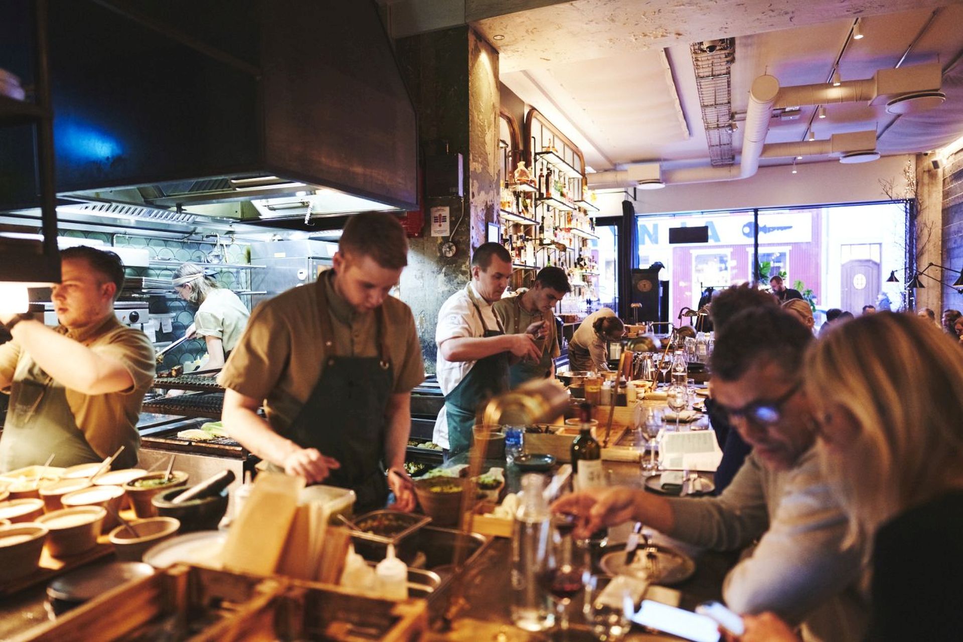Chefs plating food behind a restaurant counter in Iceland