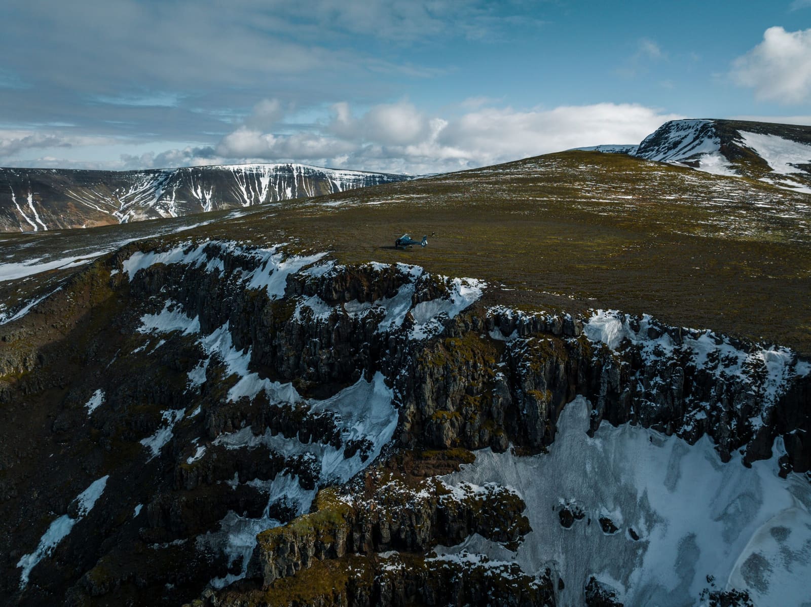 A helicopter landed on a snow-streaked mountain summit above Reykjavík.