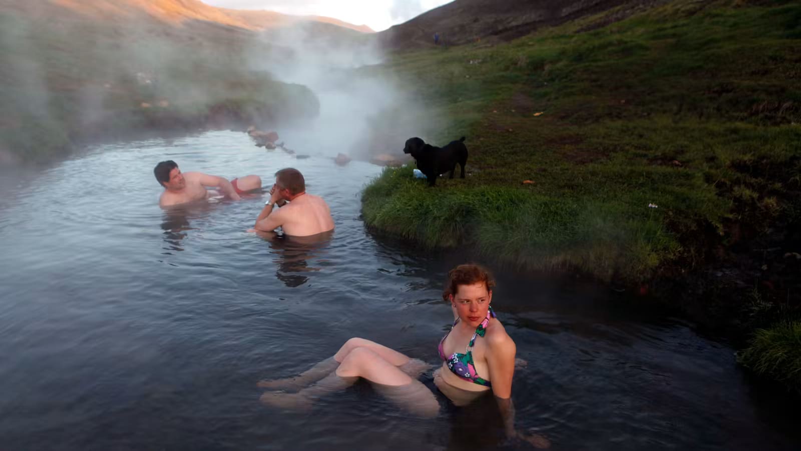 People bathing in the warm river at Reykjadalur in South Iceland