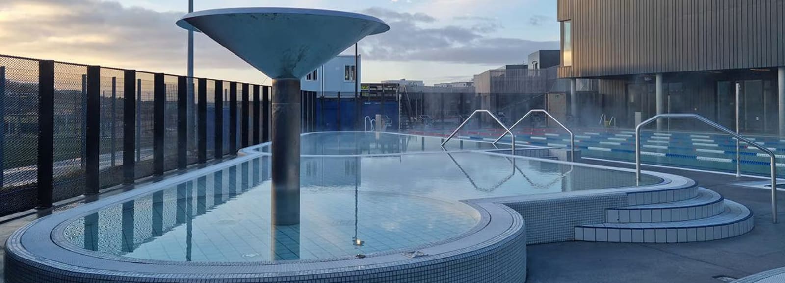 Outdoor geothermal swimming pool in Reykjavík with warm water, pool lanes, and city-pool facilities.