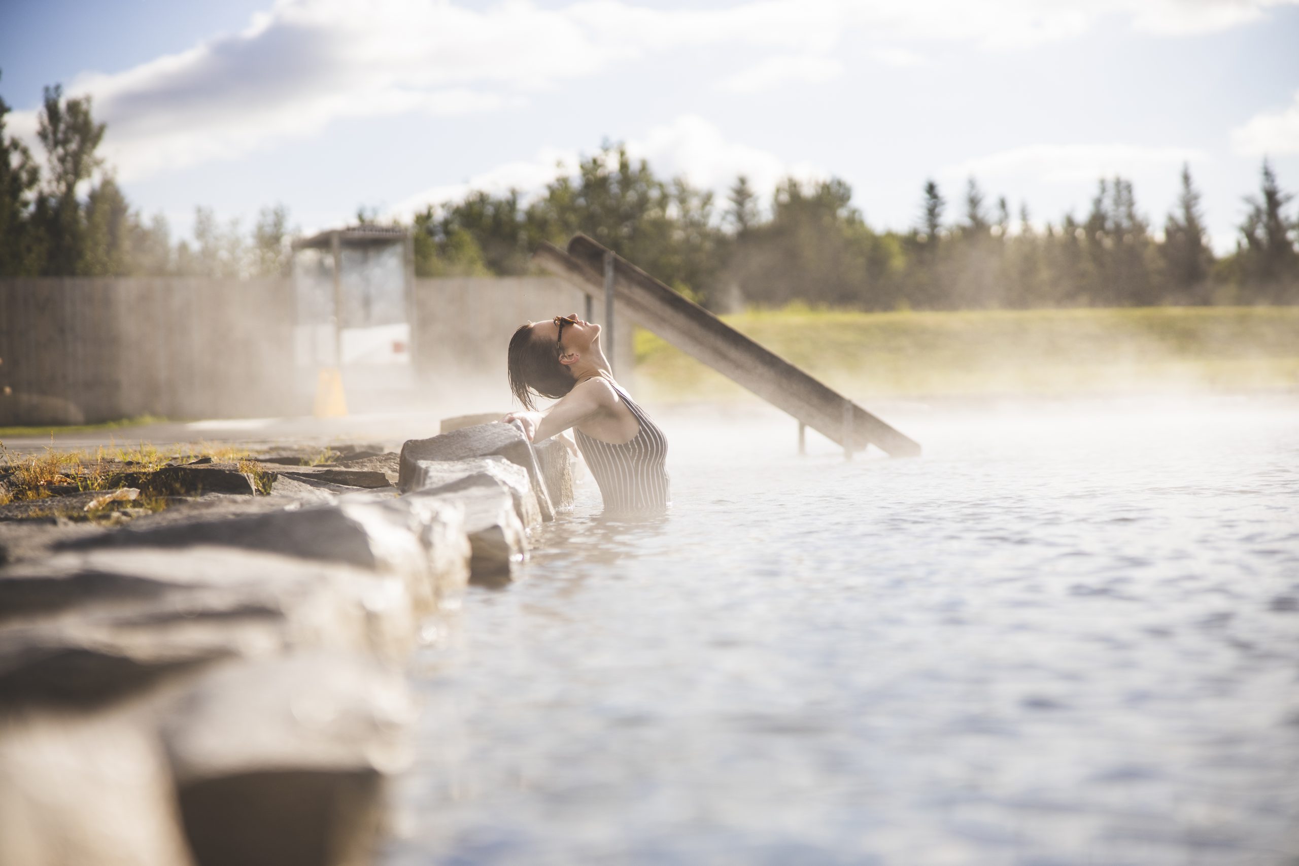 A bather relaxing in steaming water at Secret Lagoon in South Iceland