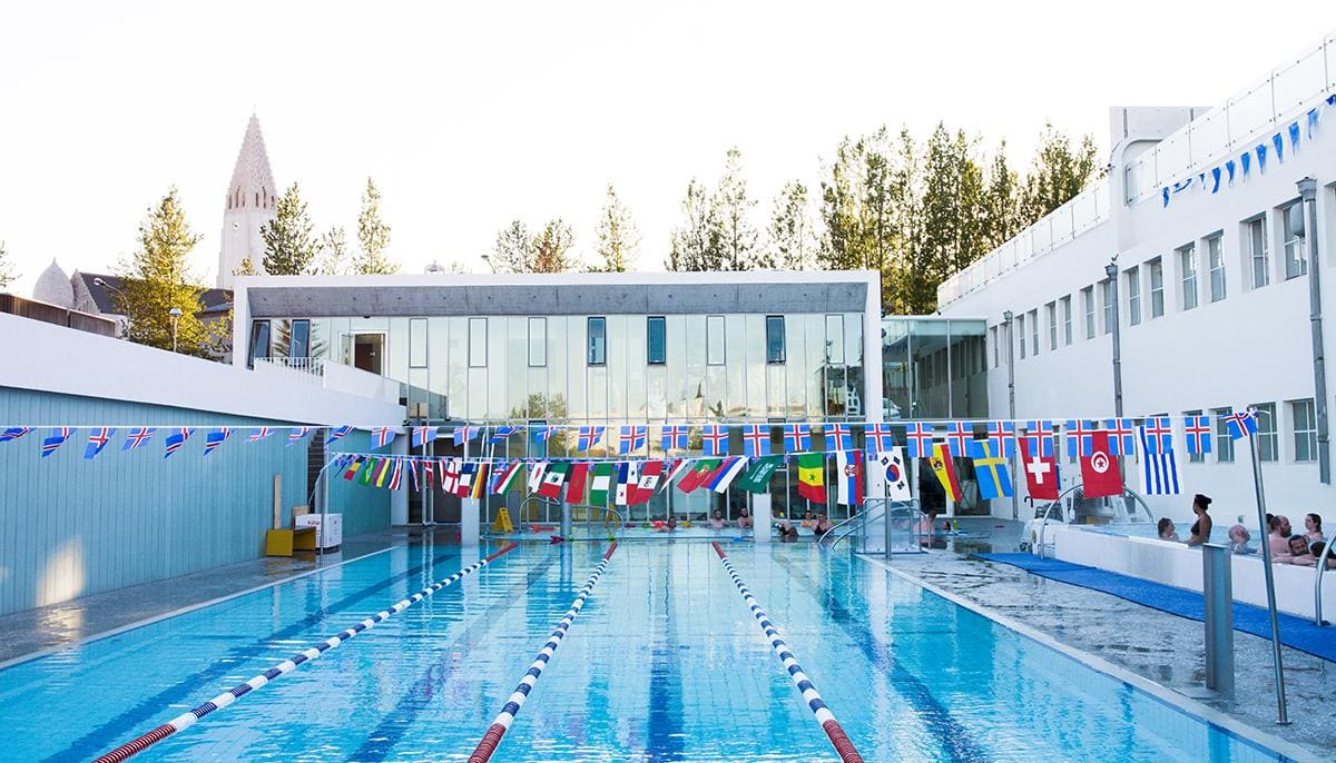 Outdoor lanes and hot-water areas with swimmers at Sundhöll in central Reykjavík