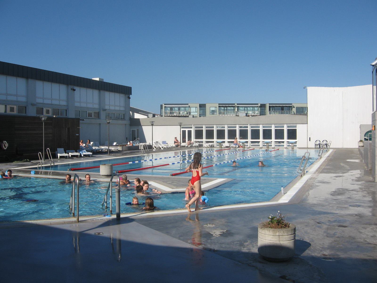 Adults and children using the lanes and hot-water area at Seltjarnarneslaug
