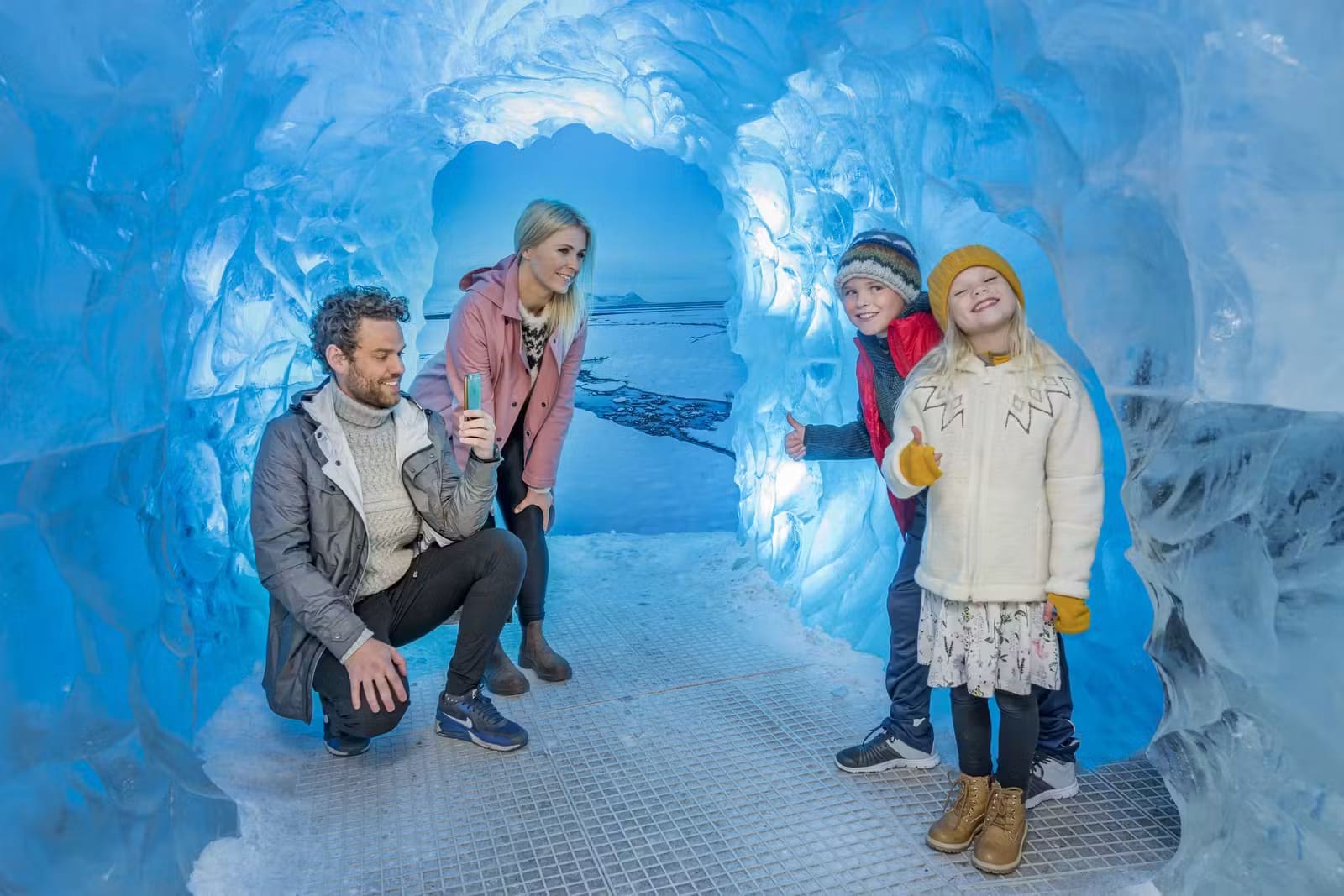 Family walking through Perlan's indoor ice cave exhibition in Reykjavík