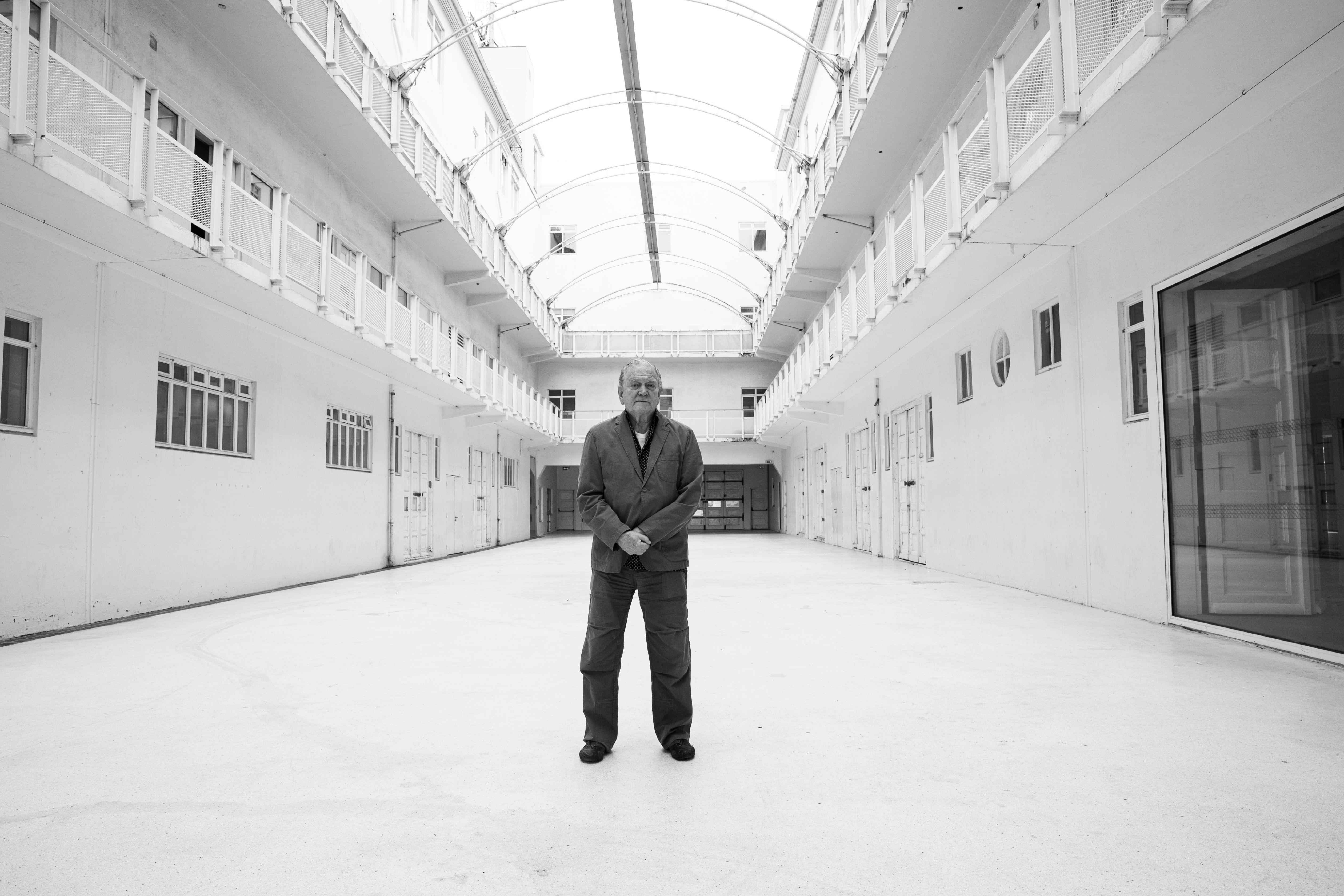 Artist Erró standing in the bright courtyard inside Hafnarhús