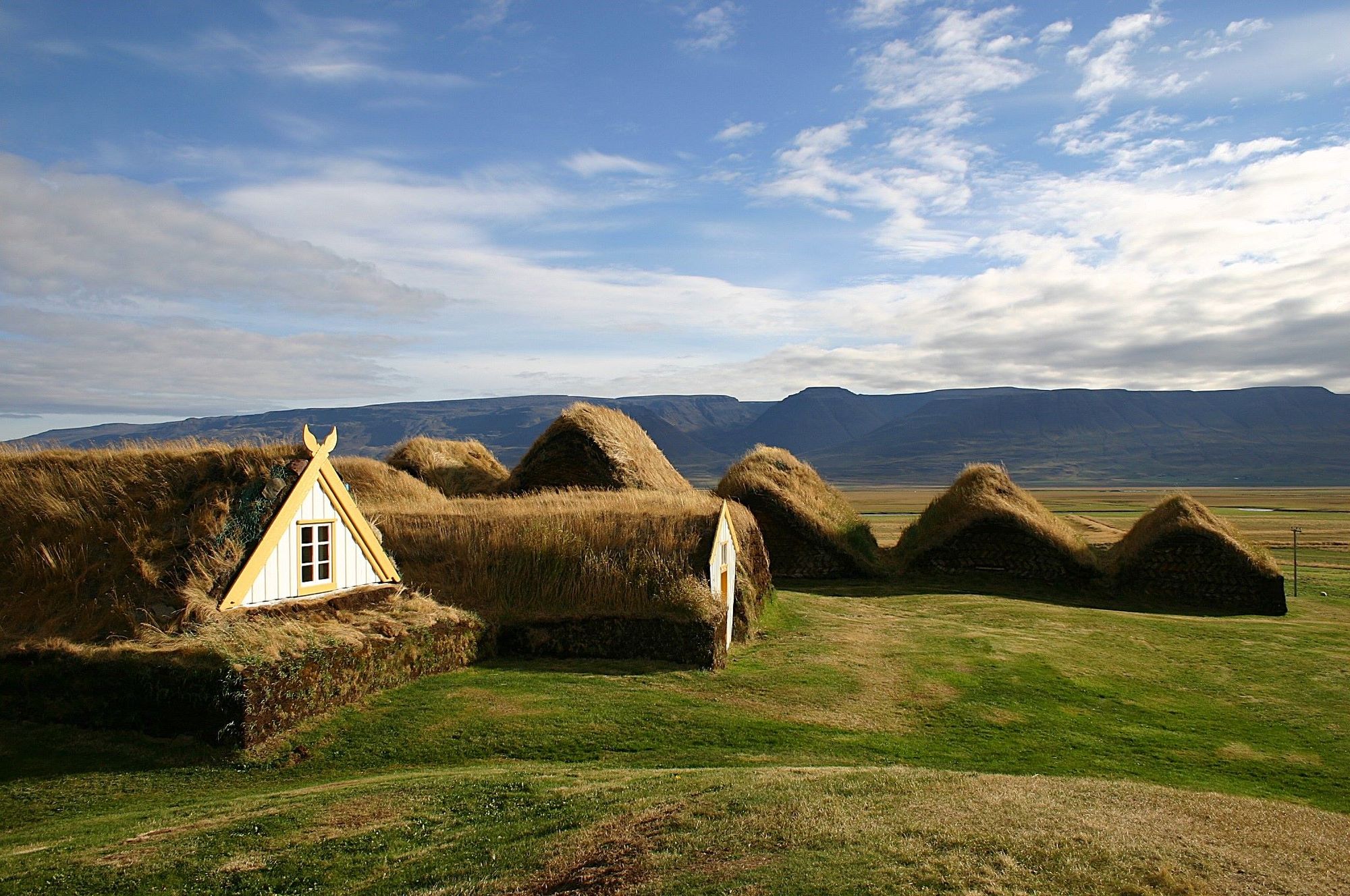 Turf-roofed buildings at Glaumbær Museum with Skagafjörður mountains behind them