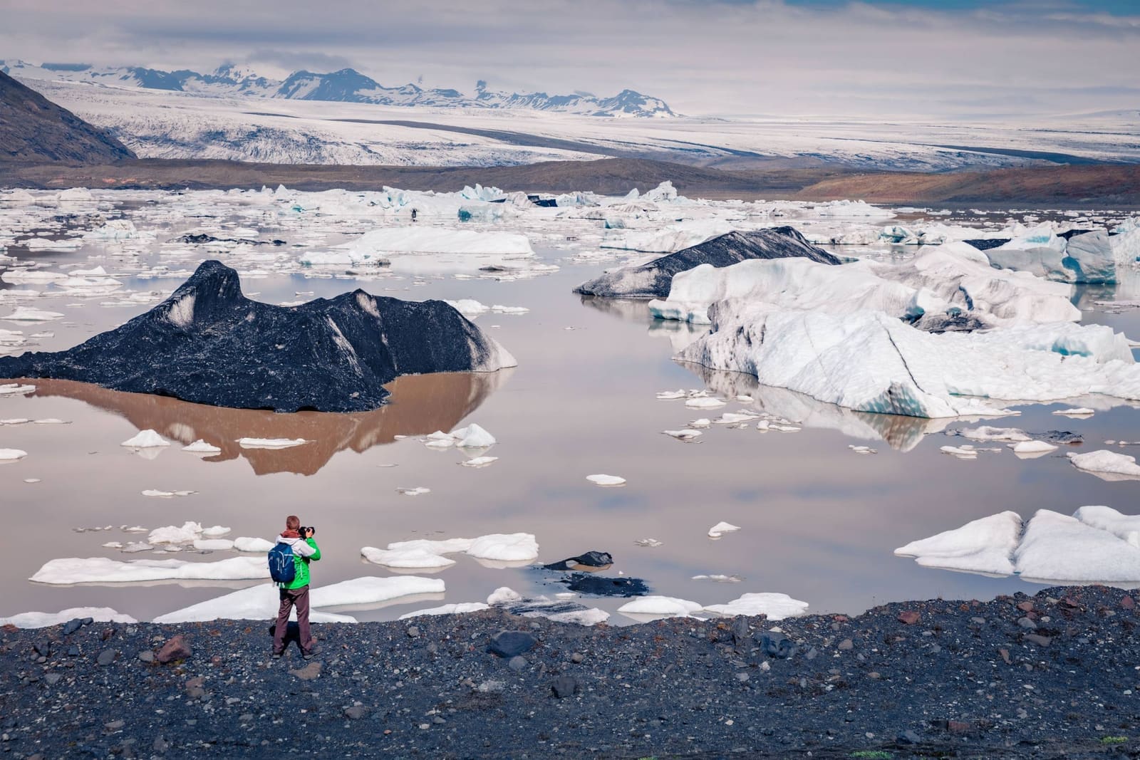 Traveler photographing floating ice at Fjallsárlón Glacier Lagoon