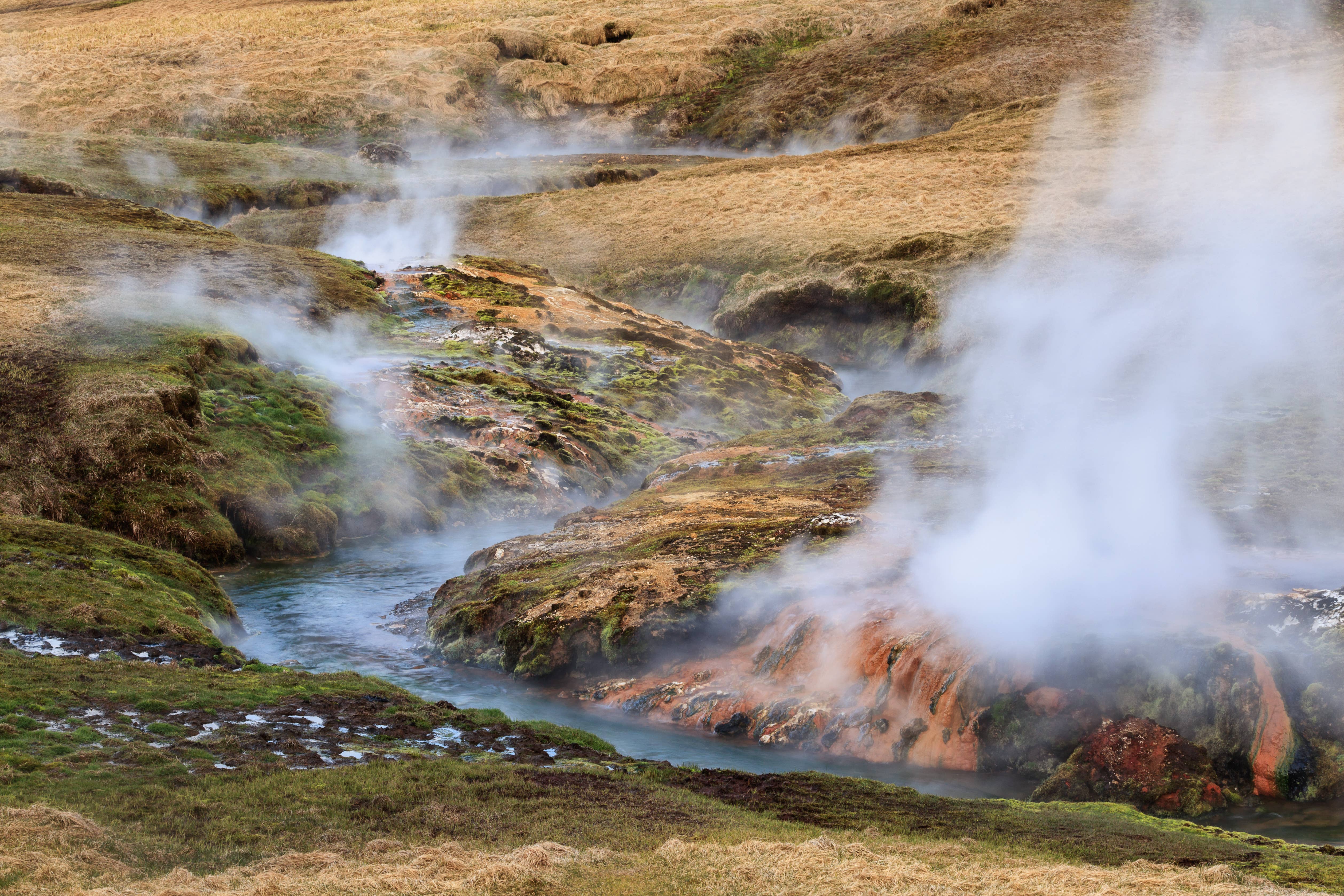 Geothermal steam drifting across wet mineral ground in Iceland