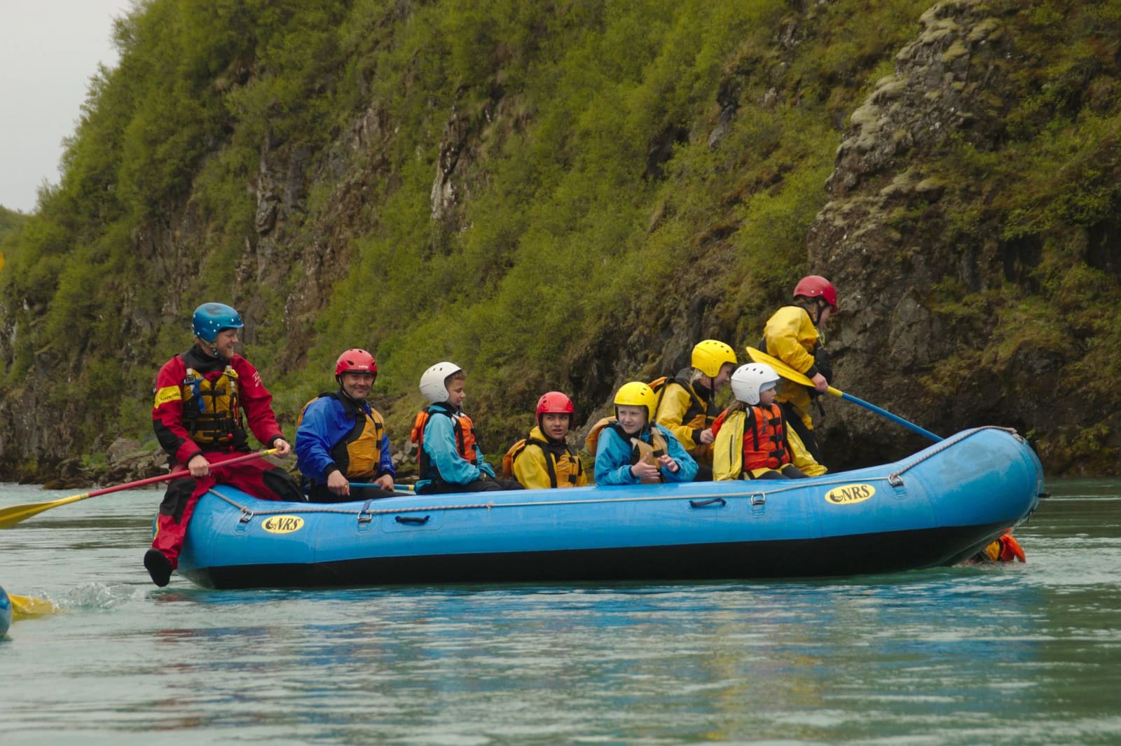 Children and adults paddling together on a calmer lower section of the Hvítá River.