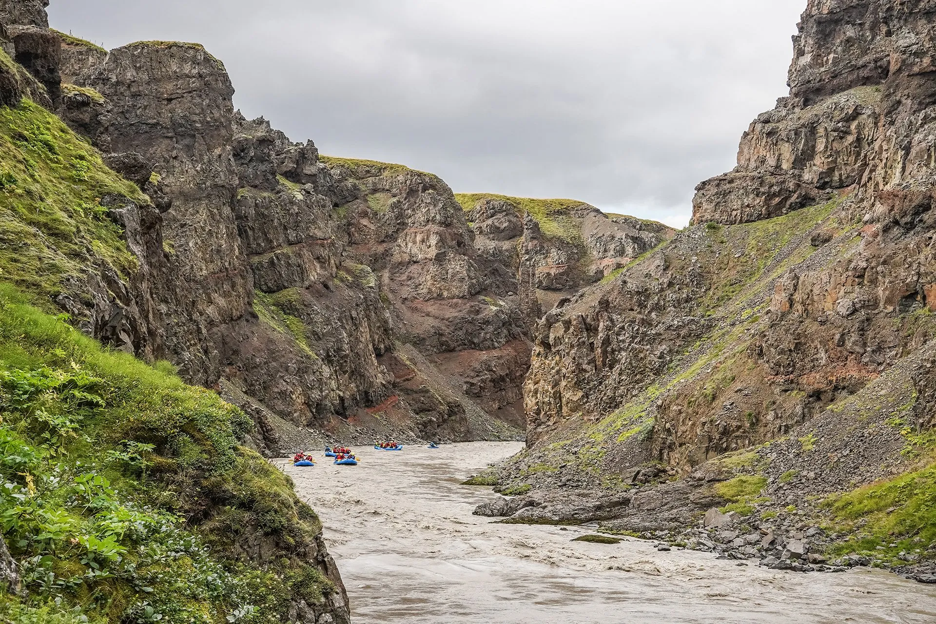Distant rafts threading the long rocky canyon of Austari Jökulsá in North Iceland.