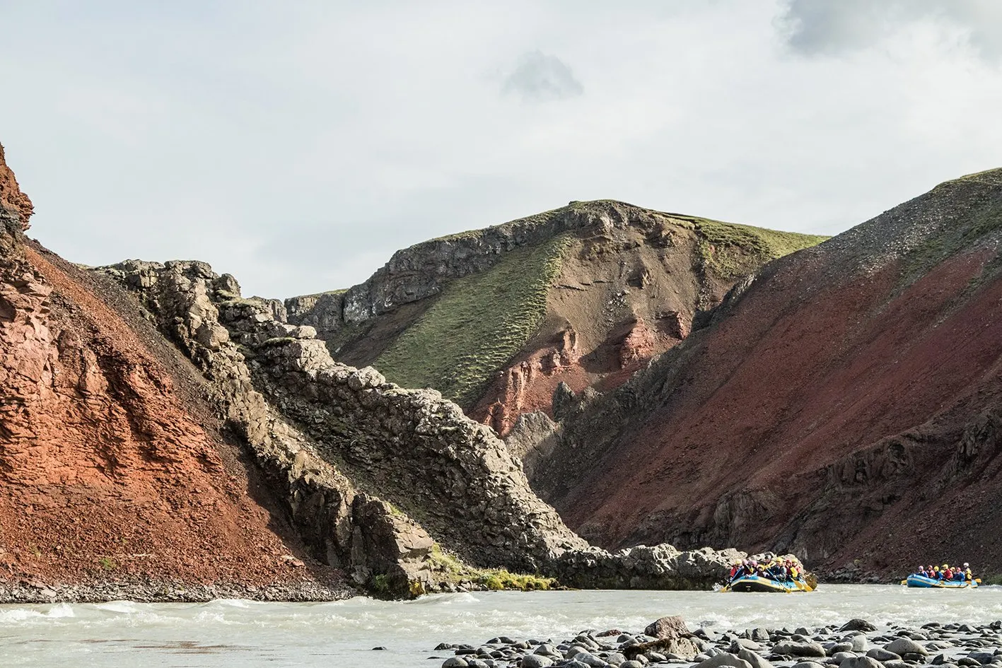Small rafts moving through the broad colorful canyon of Vestari Jökulsá in North Iceland.