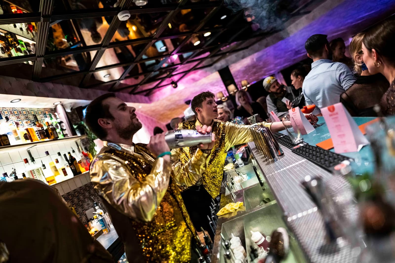Bartenders serving guests in a busy Reykjavík cocktail bar