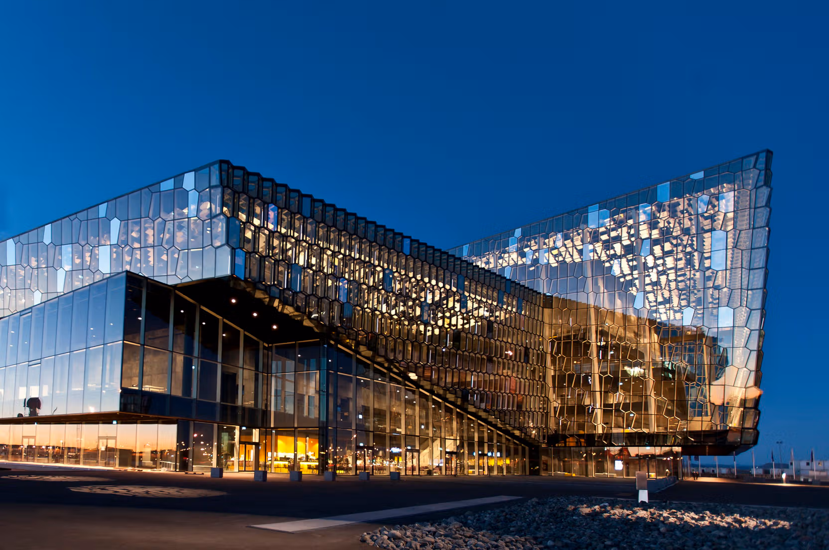 Harpa Concert Hall illuminated against a deep blue Reykjavík sky