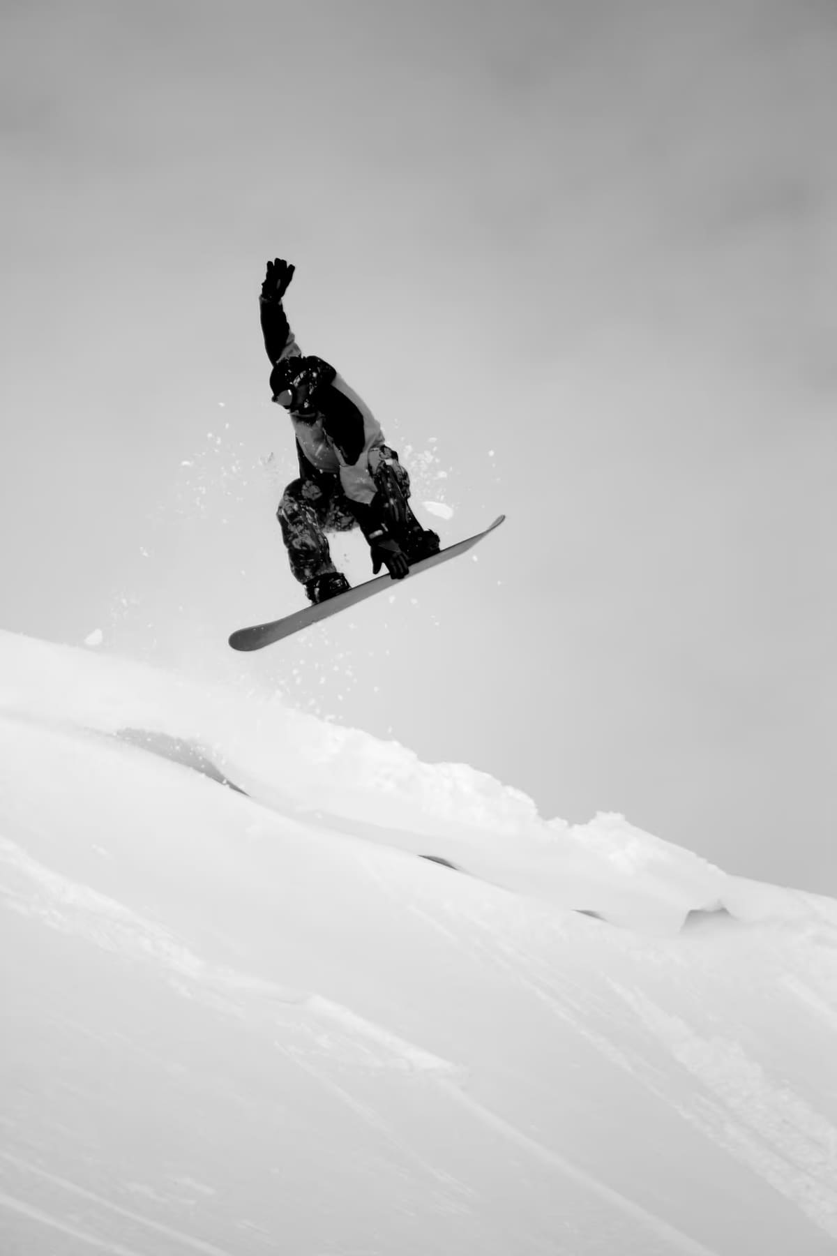 Snowboarder jumping above a snowy slope at Stafdalur in East Iceland
