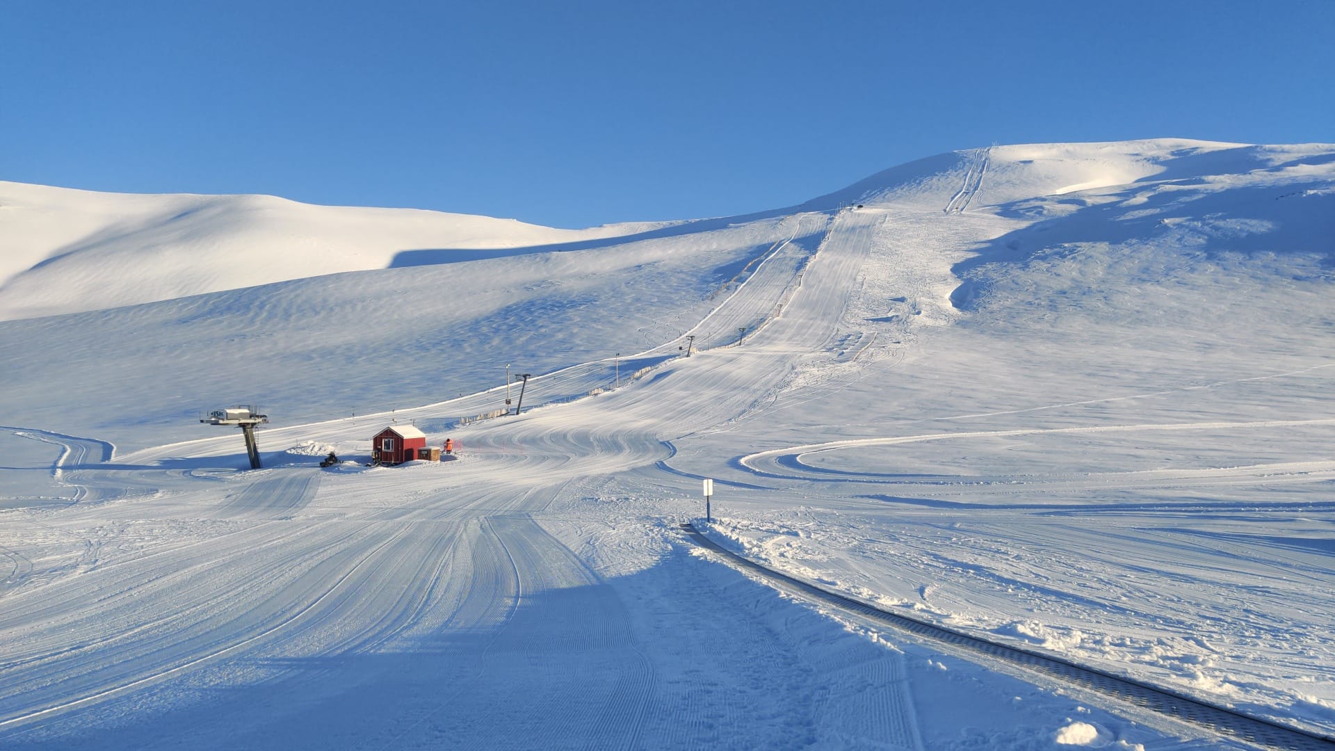 Groomed pistes and a ski lift climbing the snowy Tindastóll ski area