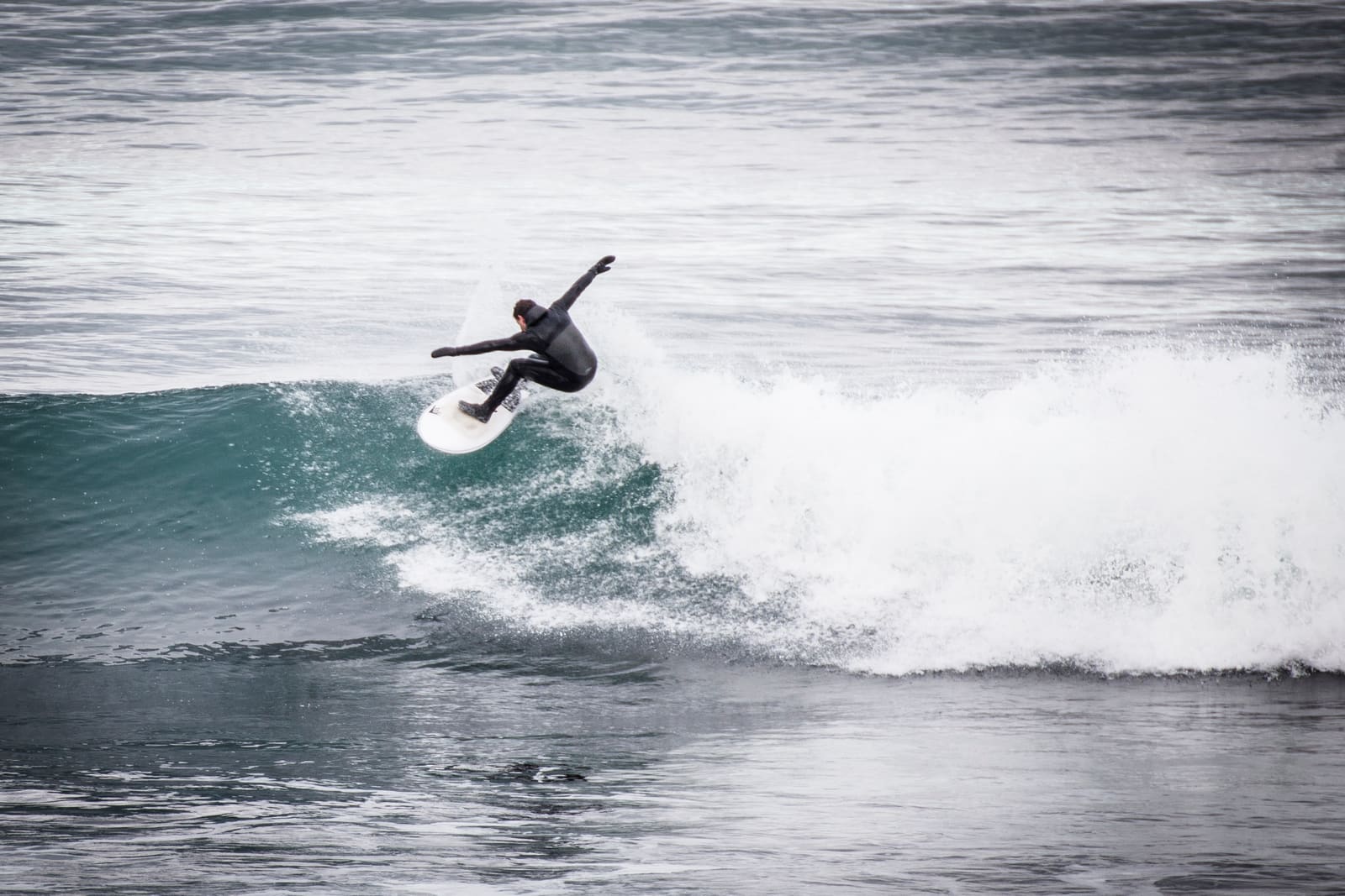 Surfer turning on a breaking wave off the coast at Þorlákshöfn