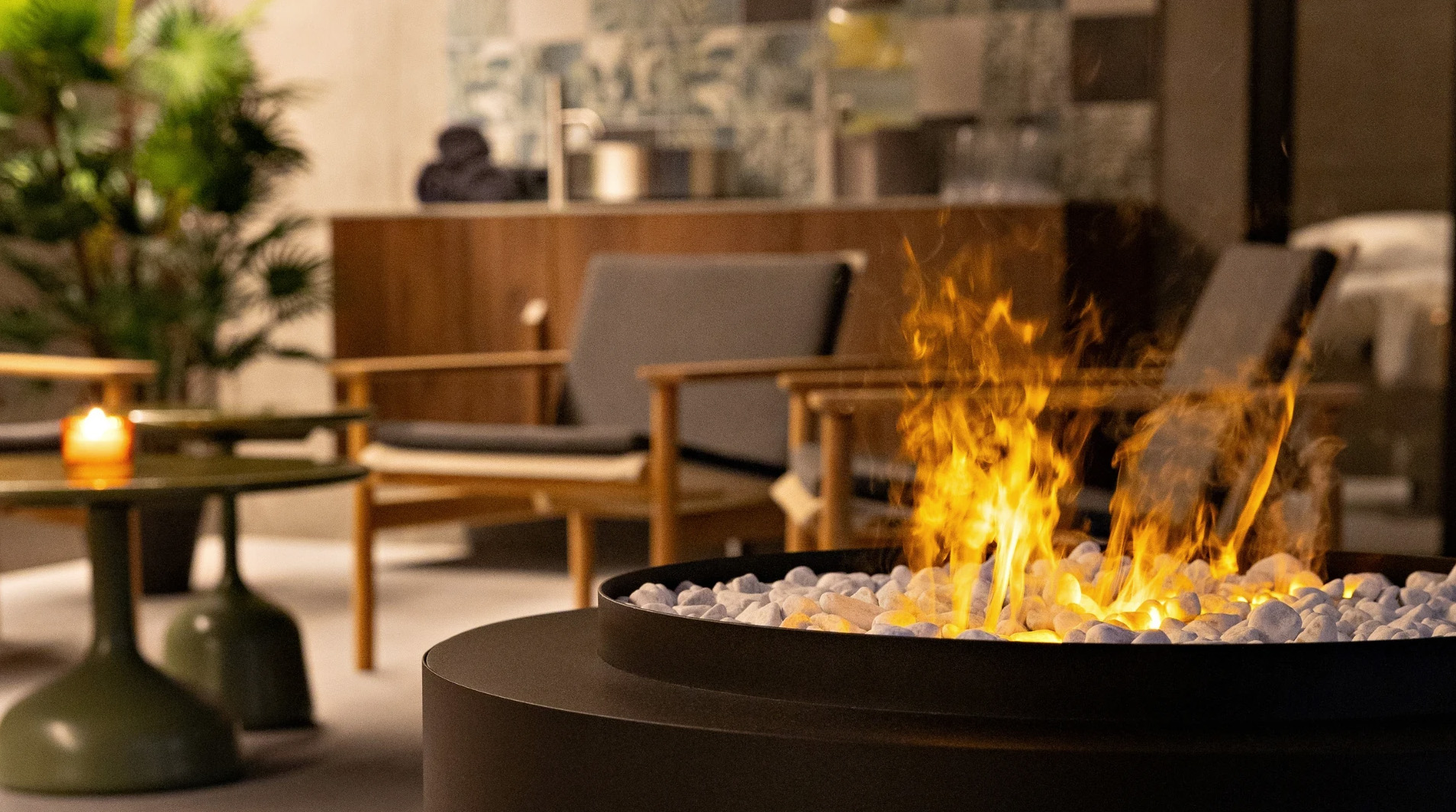 Firelit relaxation lounge with low chairs inside Grandi Spa in Reykjavík