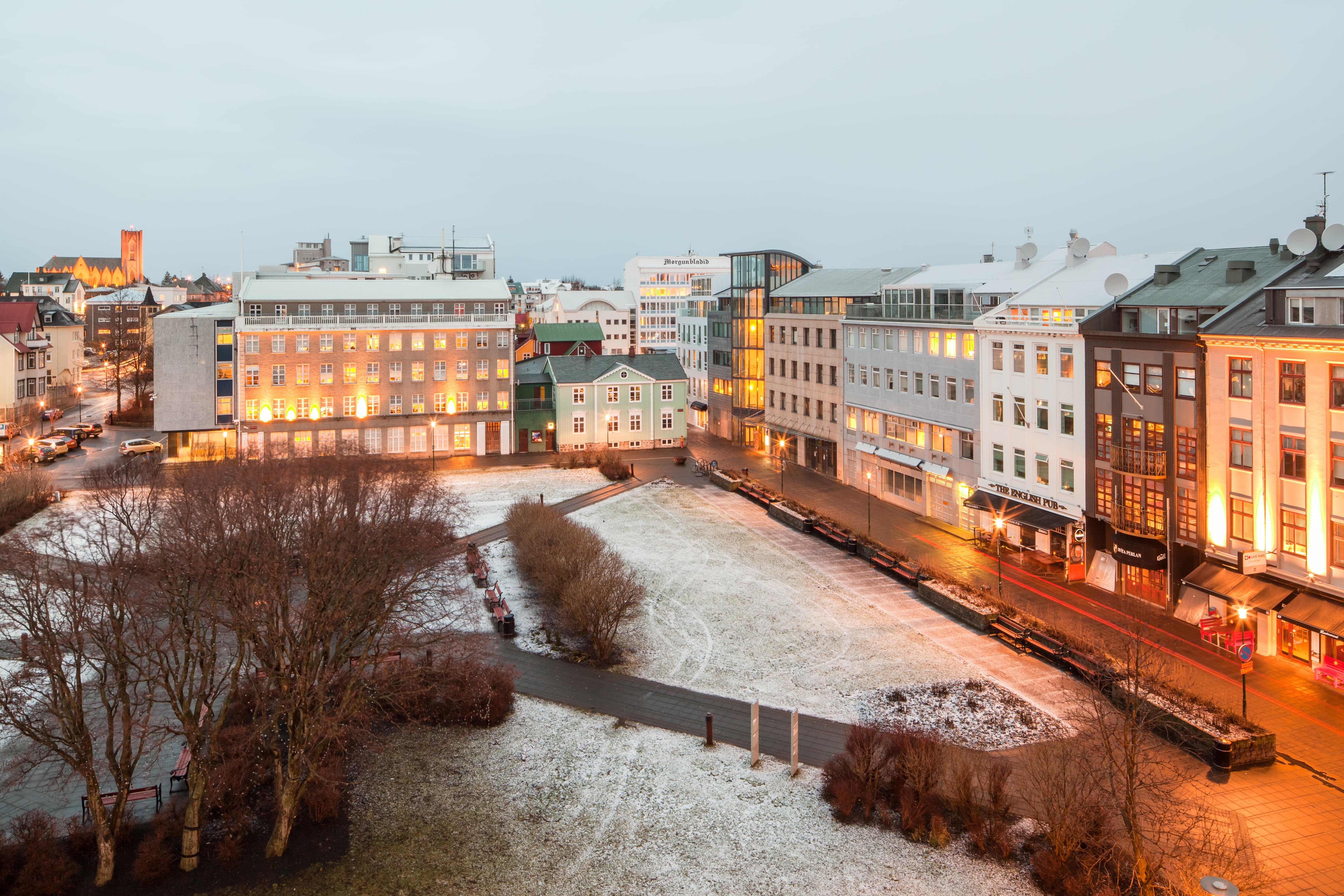 Austurvöllur square in Reykjavík with winter lights and surrounding city buildings.
