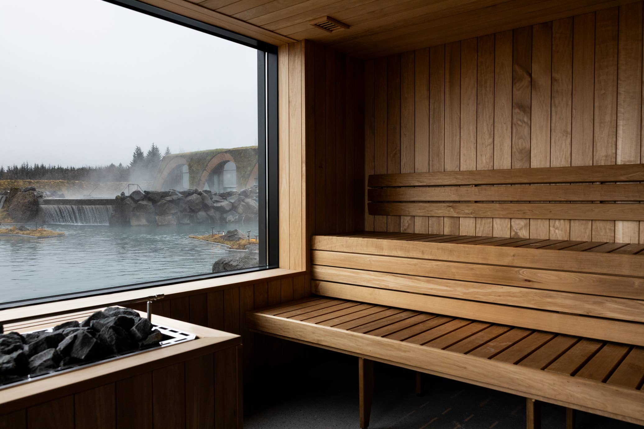 Wooden sauna interior at Laugaras Lagoon looking toward the steaming outdoor water.